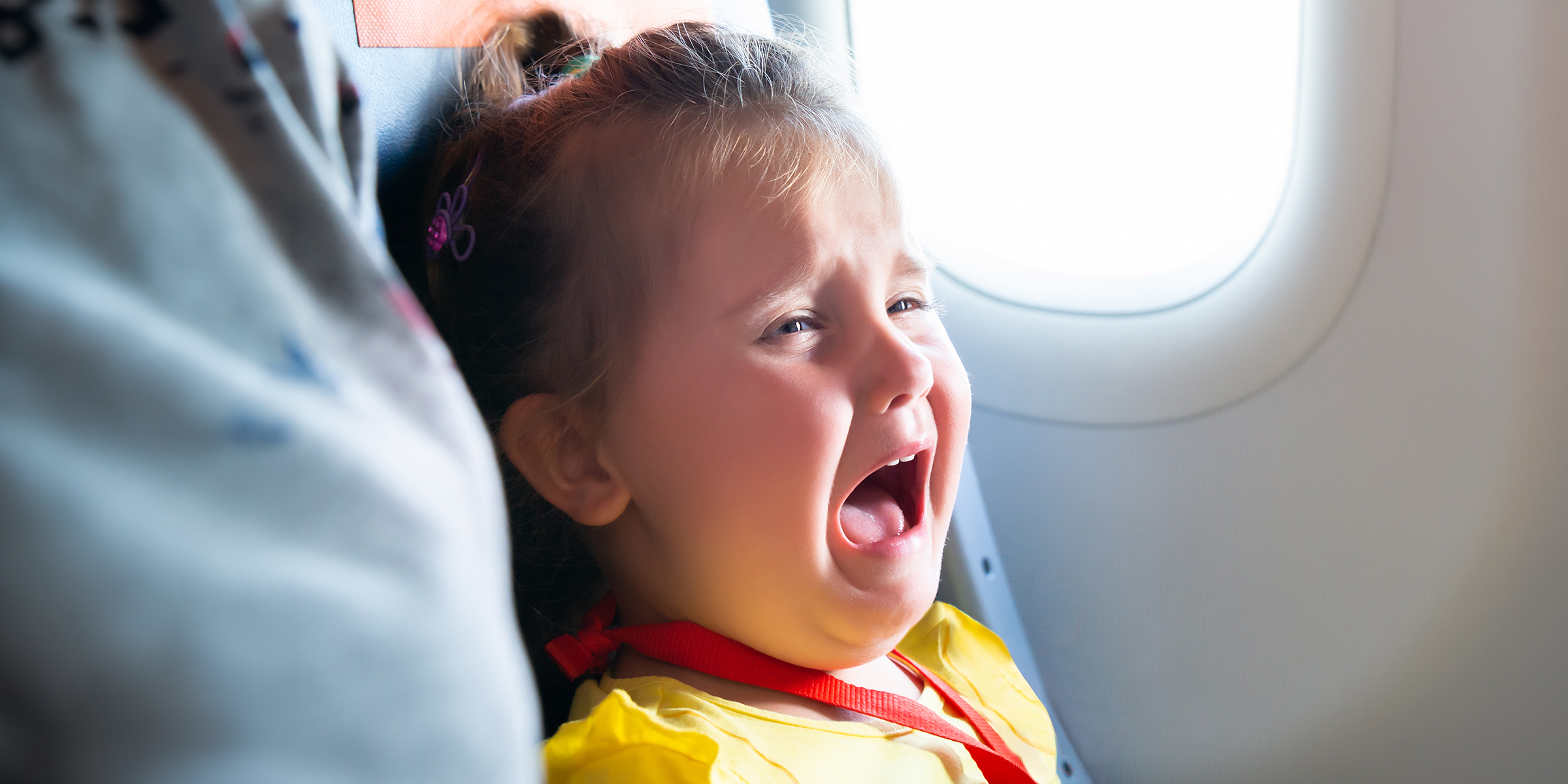 Une petite fille qui pleure dans un avion | Source : Shutterstock