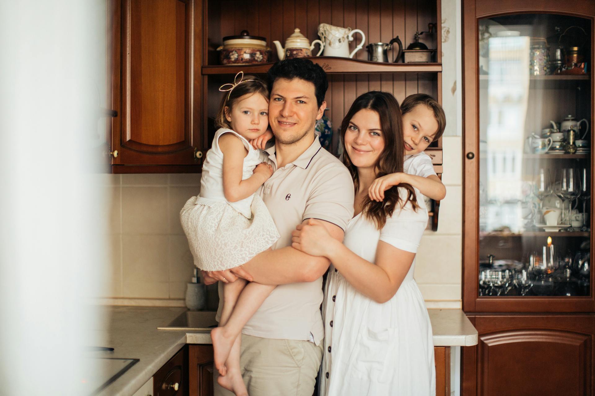 Un couple debout dans la cuisine avec leurs enfants | Source : Pexels