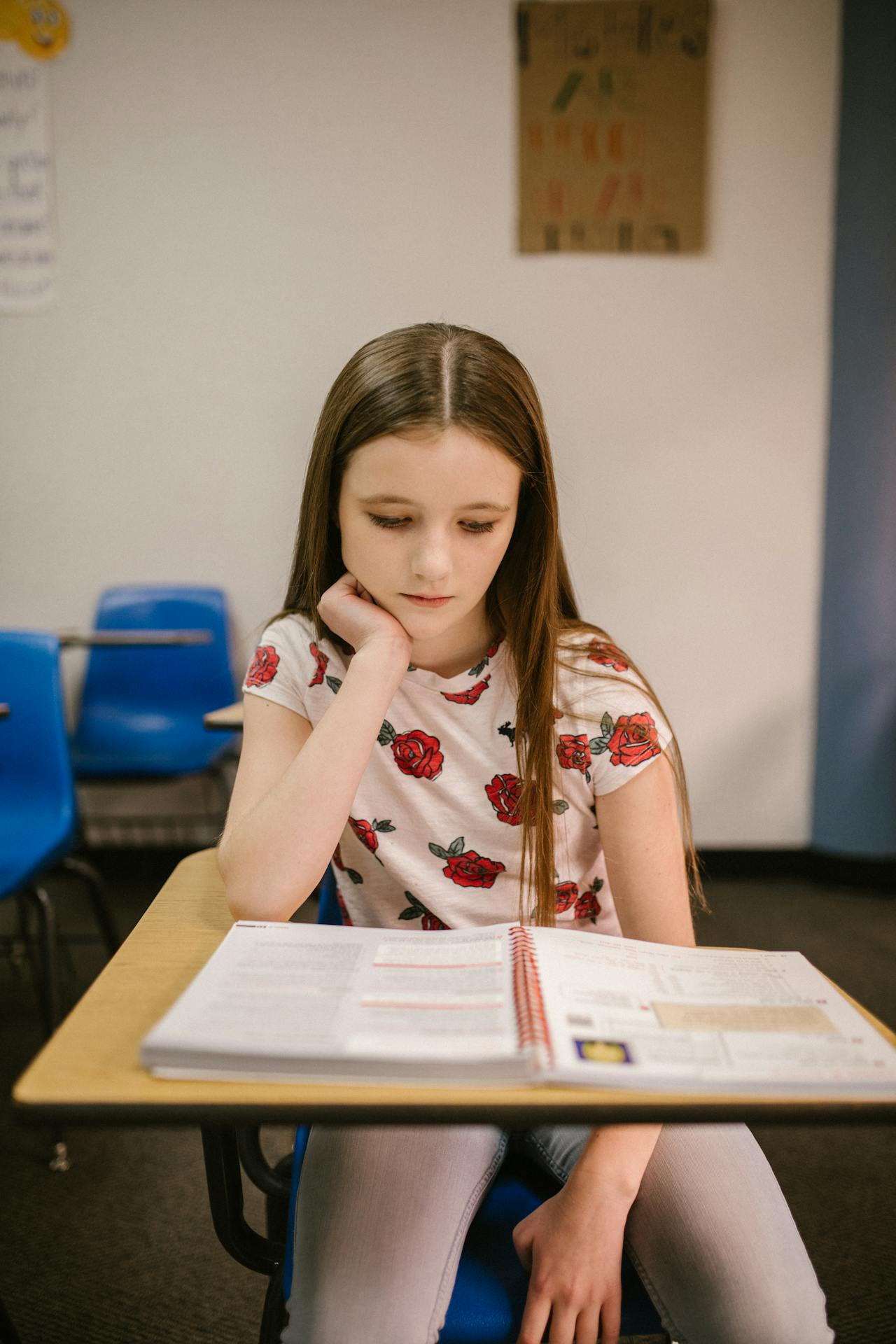 Une fille triste assise dans sa salle de classe | Source : Pexels