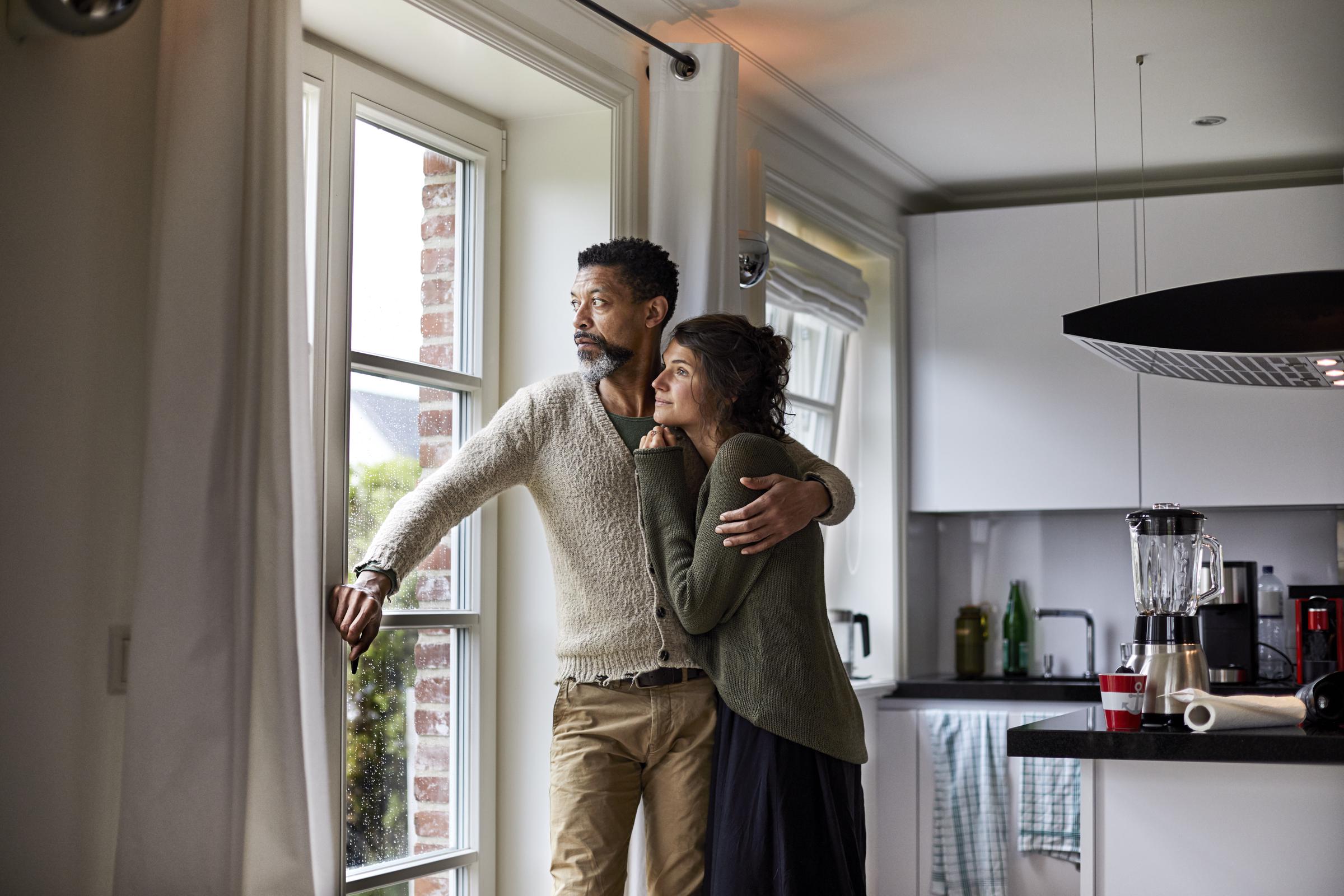 Un homme et une femme regardant par la fenêtre | Source : Getty Images