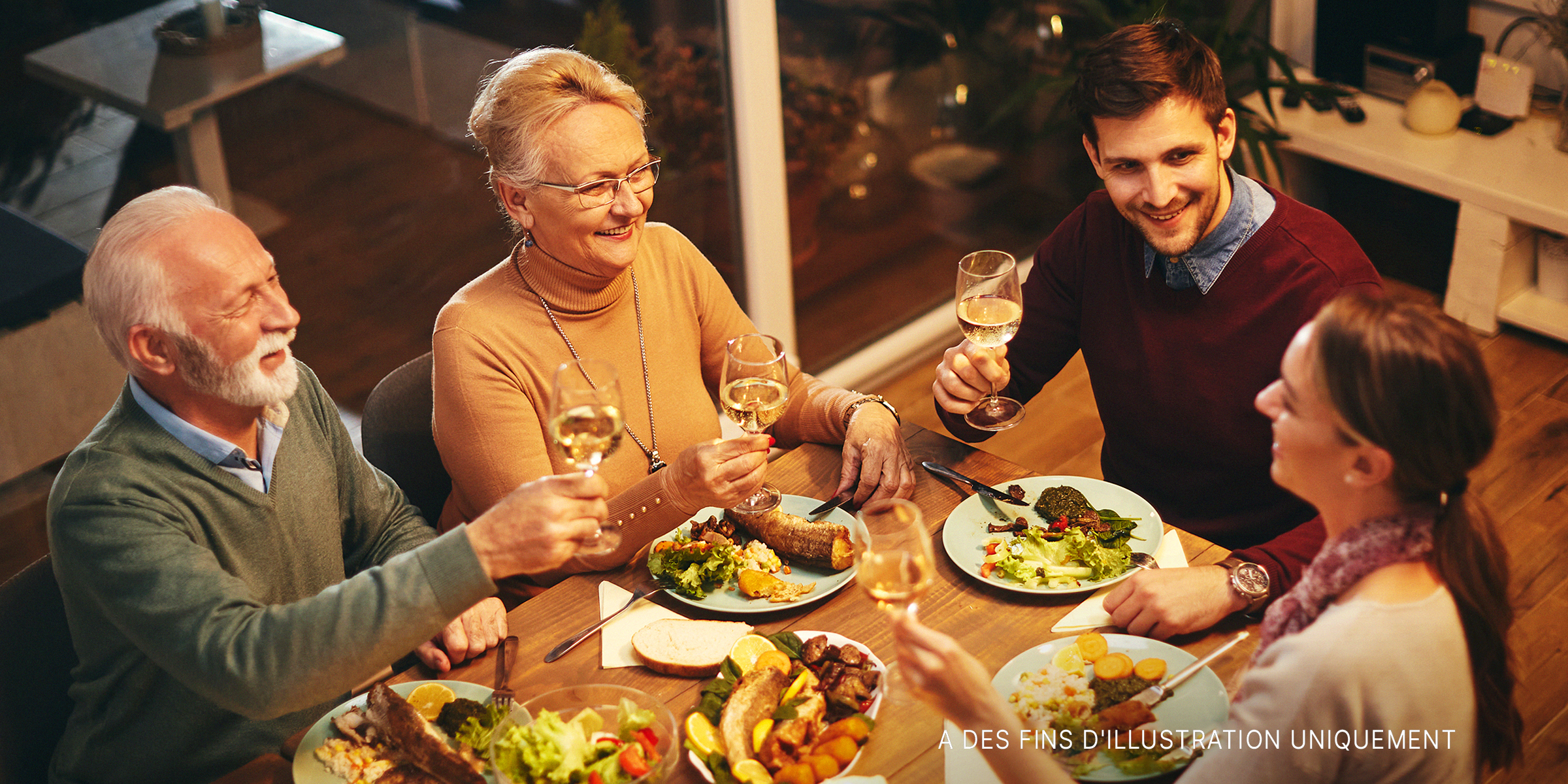 Une famille heureuse partageant un toast pendant le dîner | Source : Shutterstock