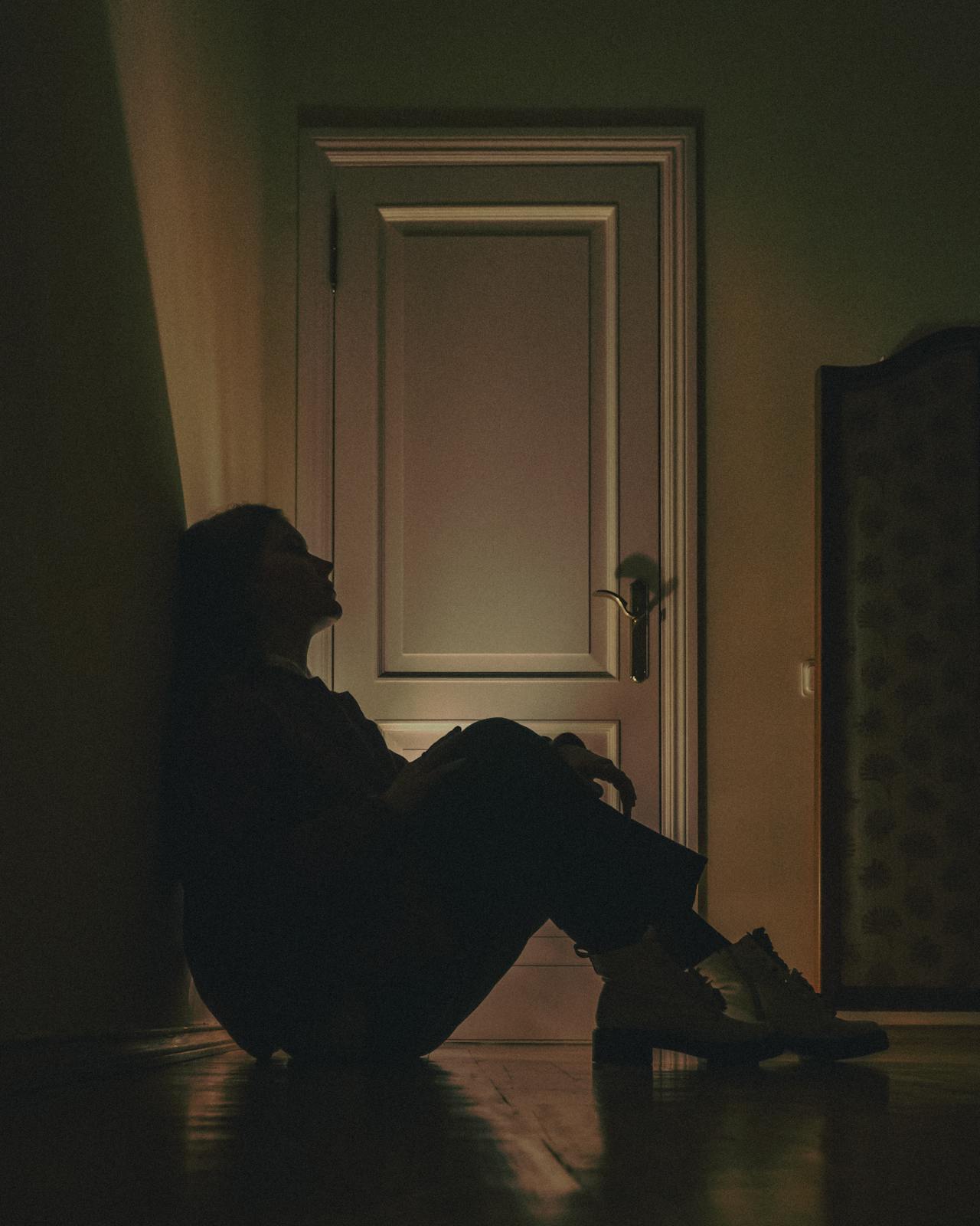 Une jeune femme défaite assise sur le sol | Source : Pexels