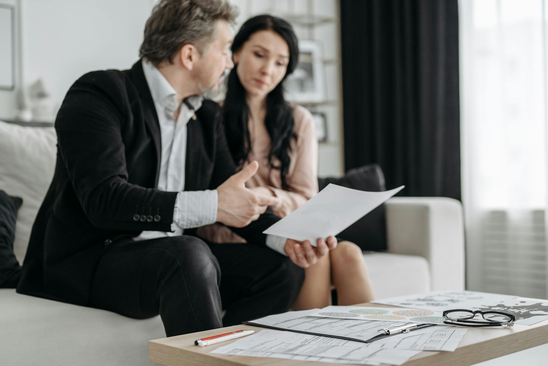 Une femme et un homme parcourant des papiers dans un bureau | Source : Pexels