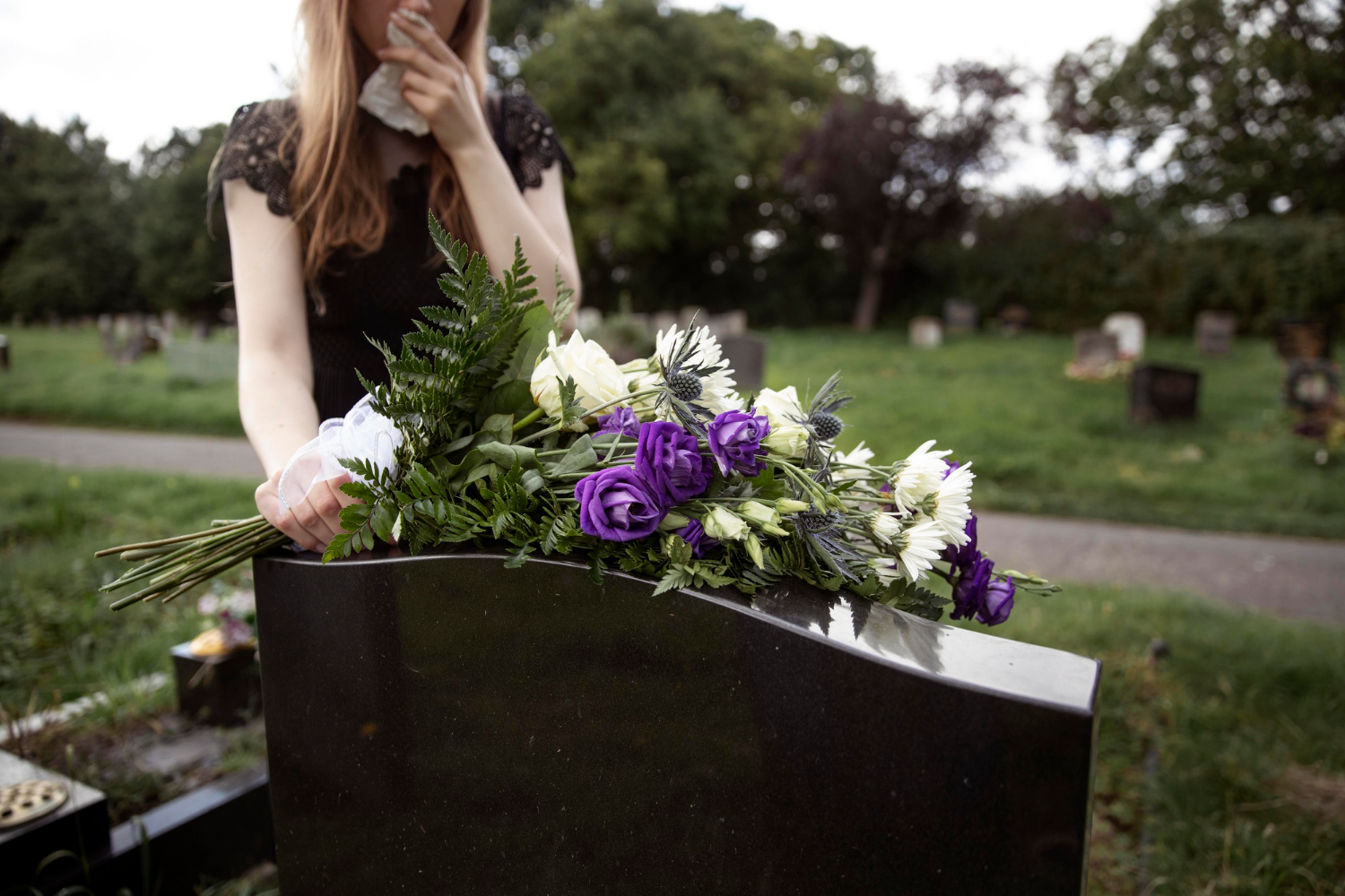Une femme en deuil se rendant sur la tombe d'un être cher | Source : Freepik