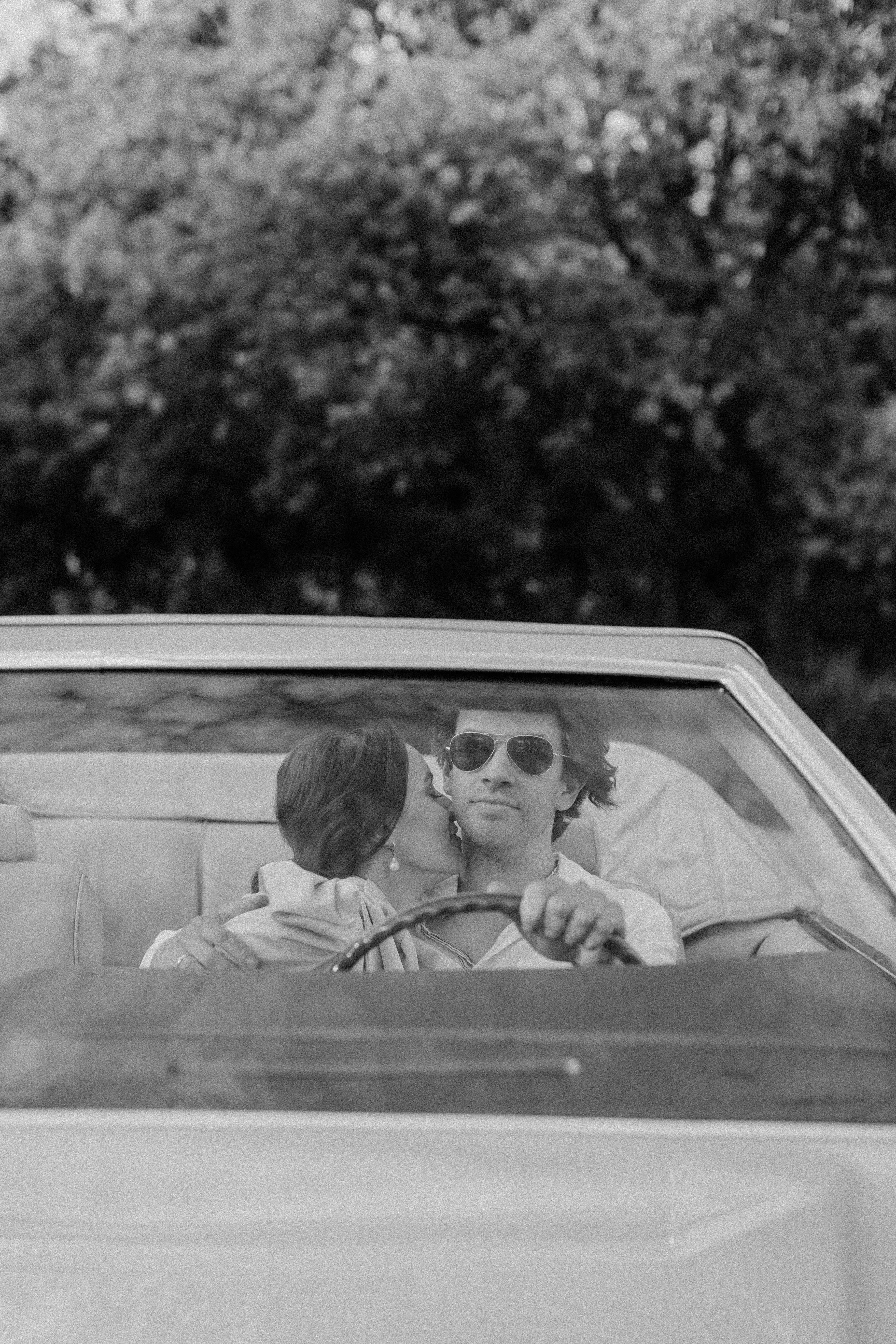 Un homme qui conduit pendant qu’une femme l’embrasse | Source : Pexels