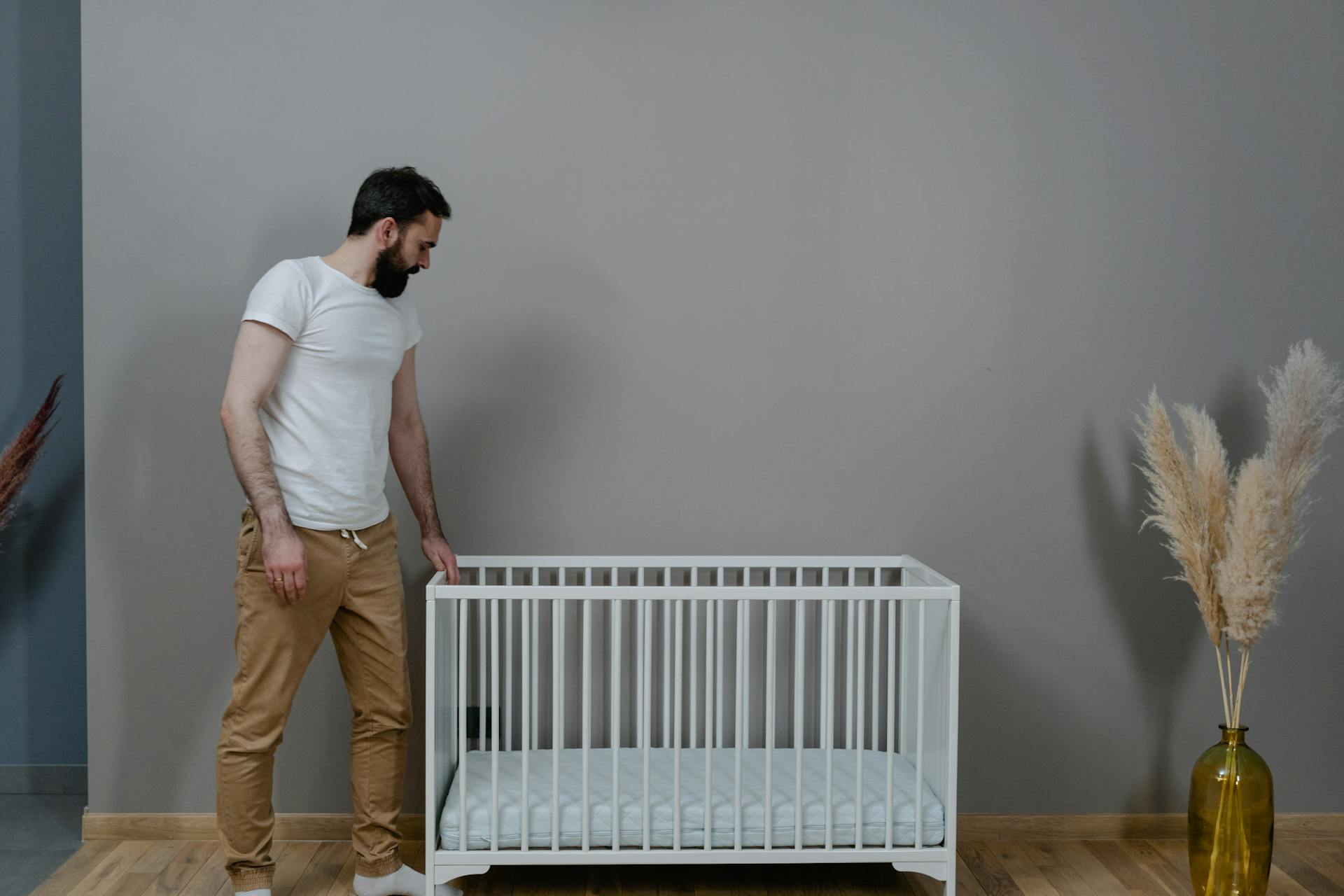 Un homme debout près d'un berceau | Source : Pexels
