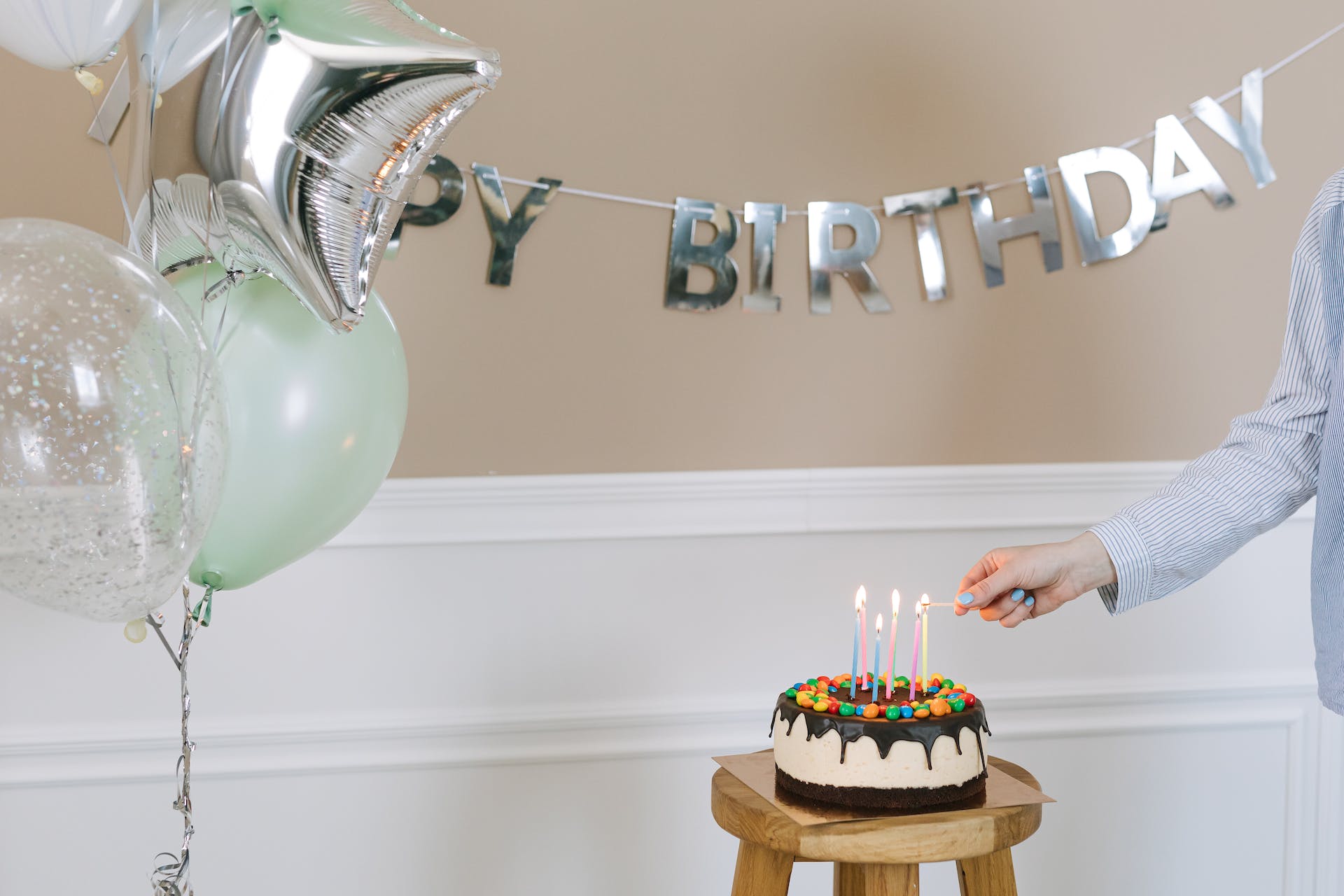 Una persona encendiendo una vela en una tarta de cumpleaños | Fuente: Pexels