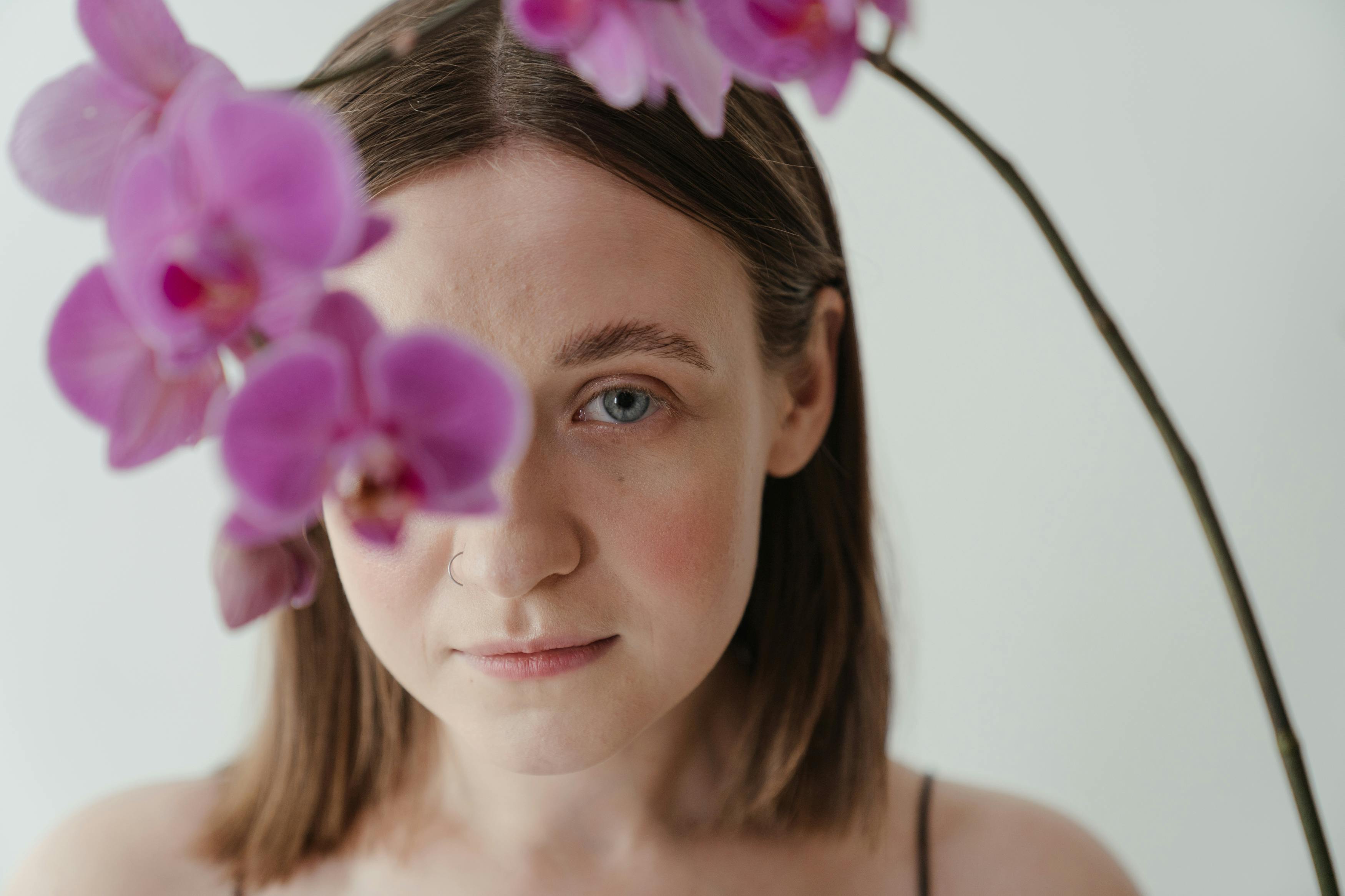 Une femme posant avec des fleurs violettes | Source : Pexels