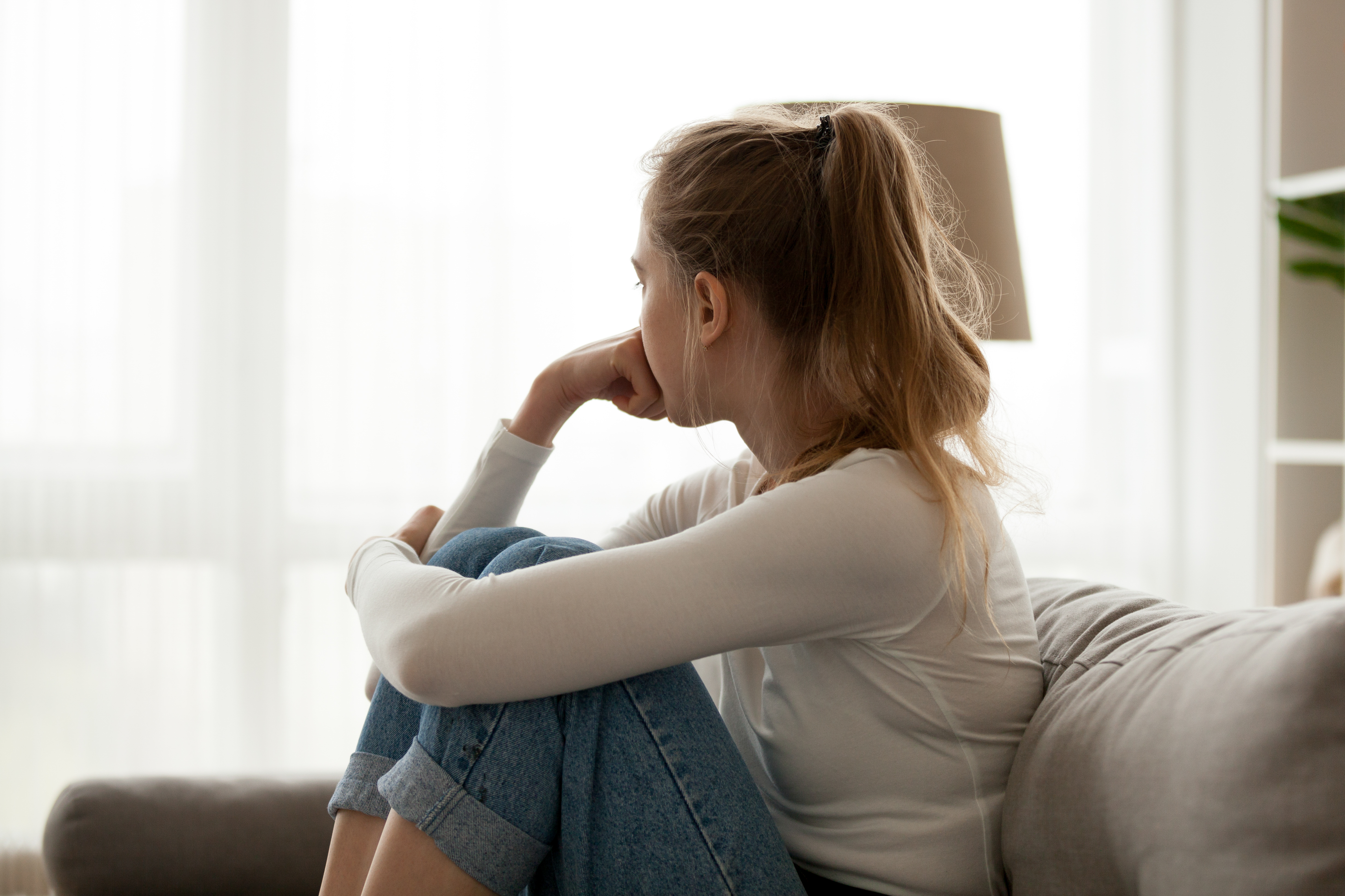 Une jeune femme malheureuse qui regarde la fenêtre | Source : Shutterstock