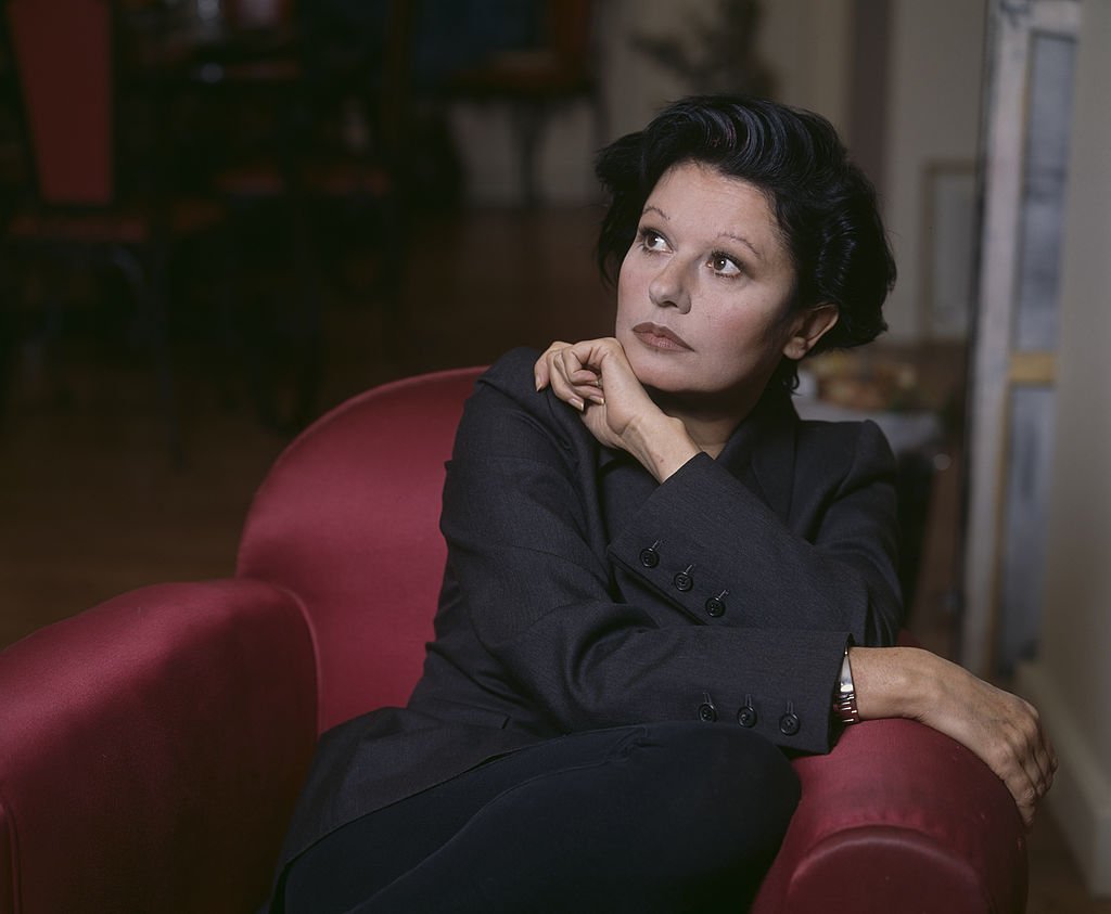 Patti Guesh à la maison. En France, en novembre 1992, Guesch PATTI, chanteuse, chez elle, assise dans un fauteuil dans le salon de son appartement. | Photo : Getty Images
