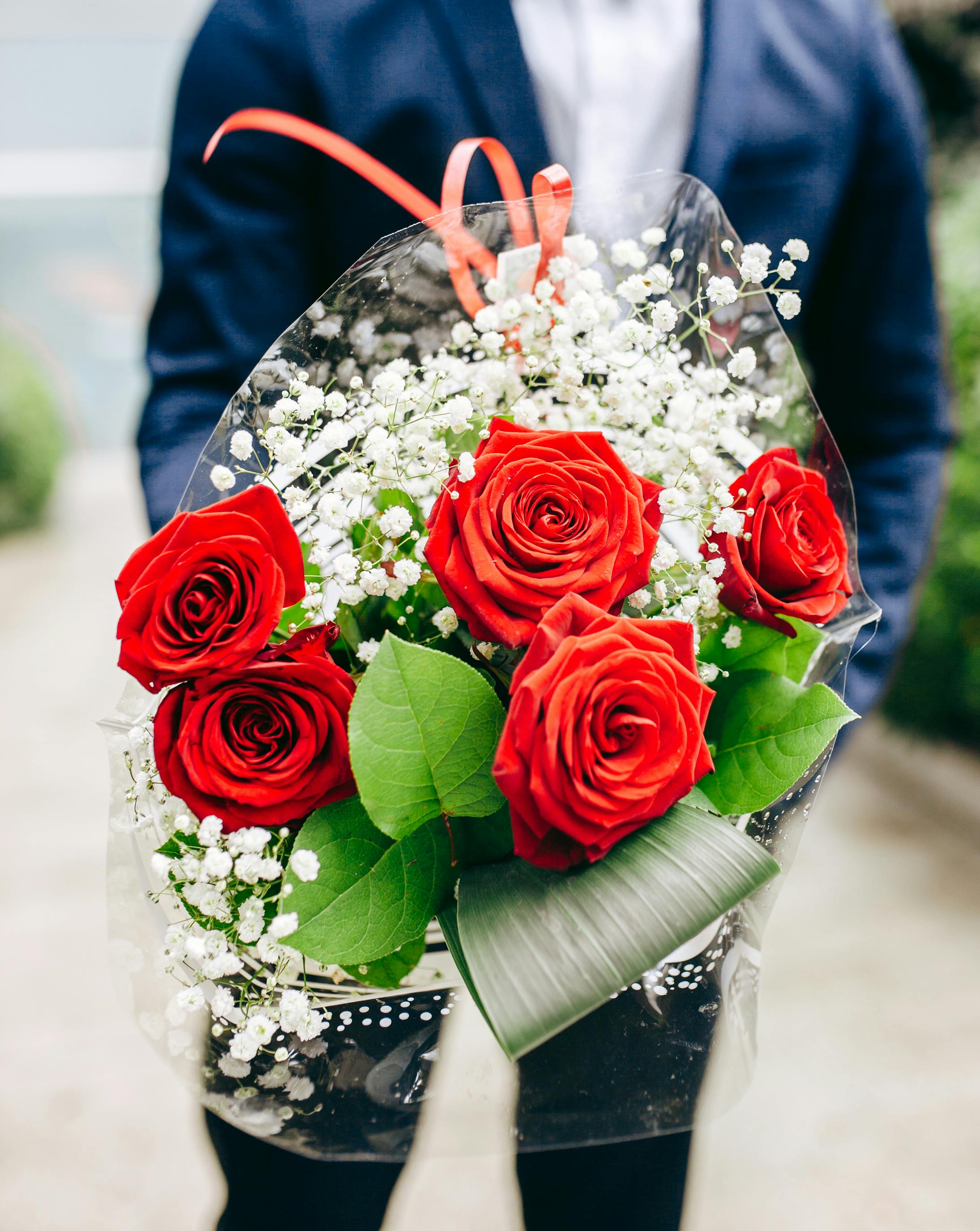 Un homme serrant un bouquet de fleurs | Source : Pexels