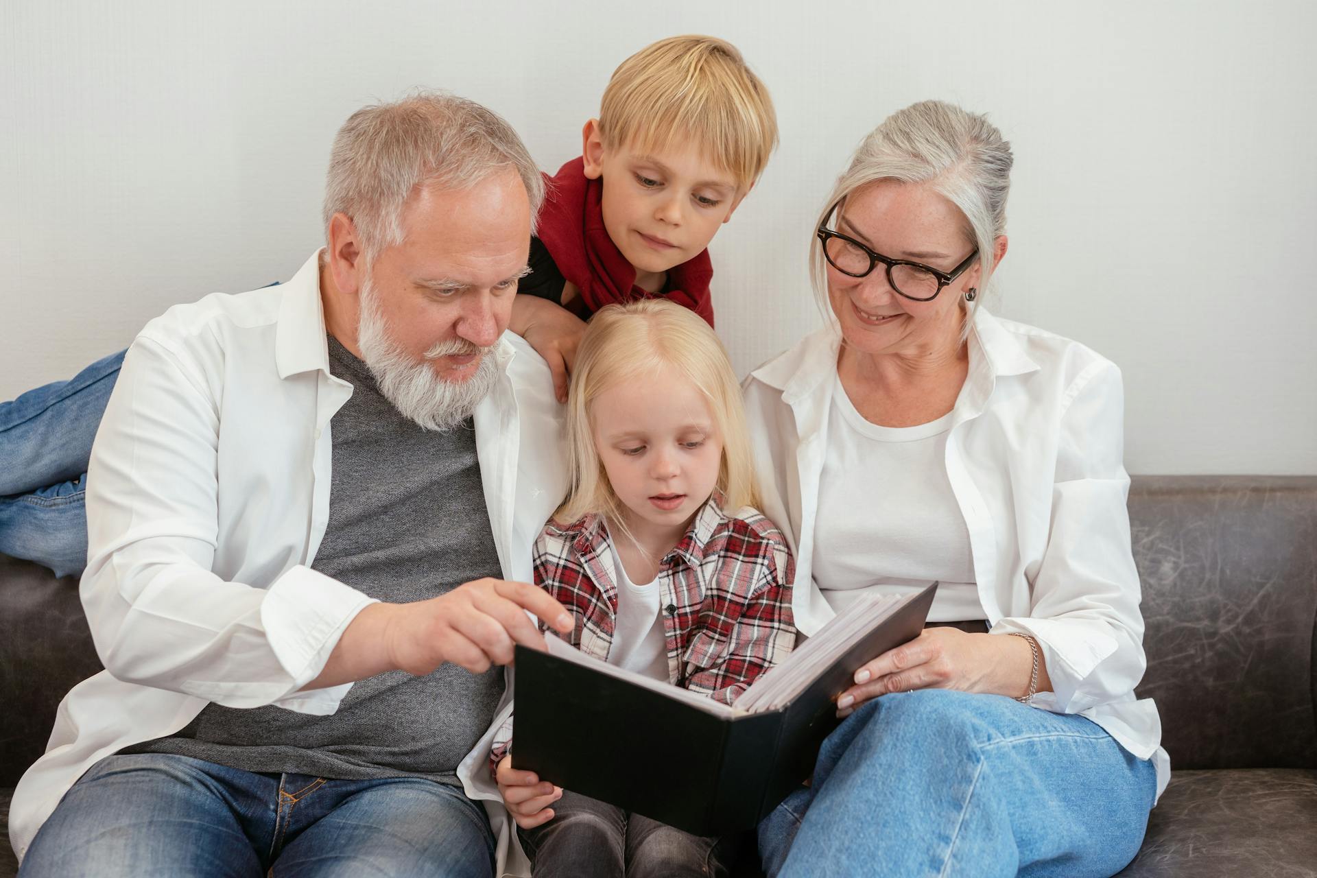 Des grands-parents regardent un album photo avec leurs petits-enfants | Source : Pexels