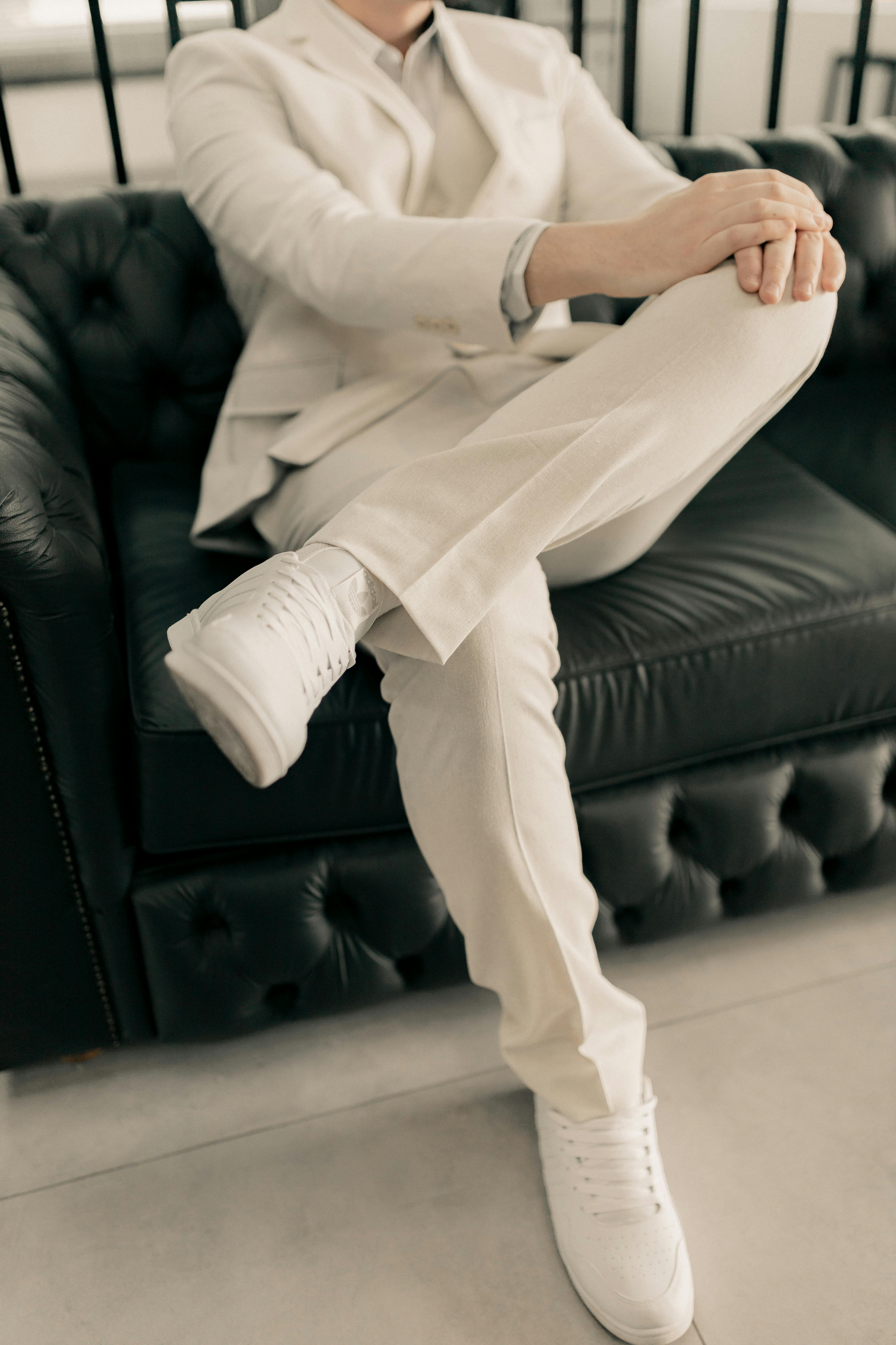 Personne en costume beige assise sur un canapé en cuir | Source : Pexels