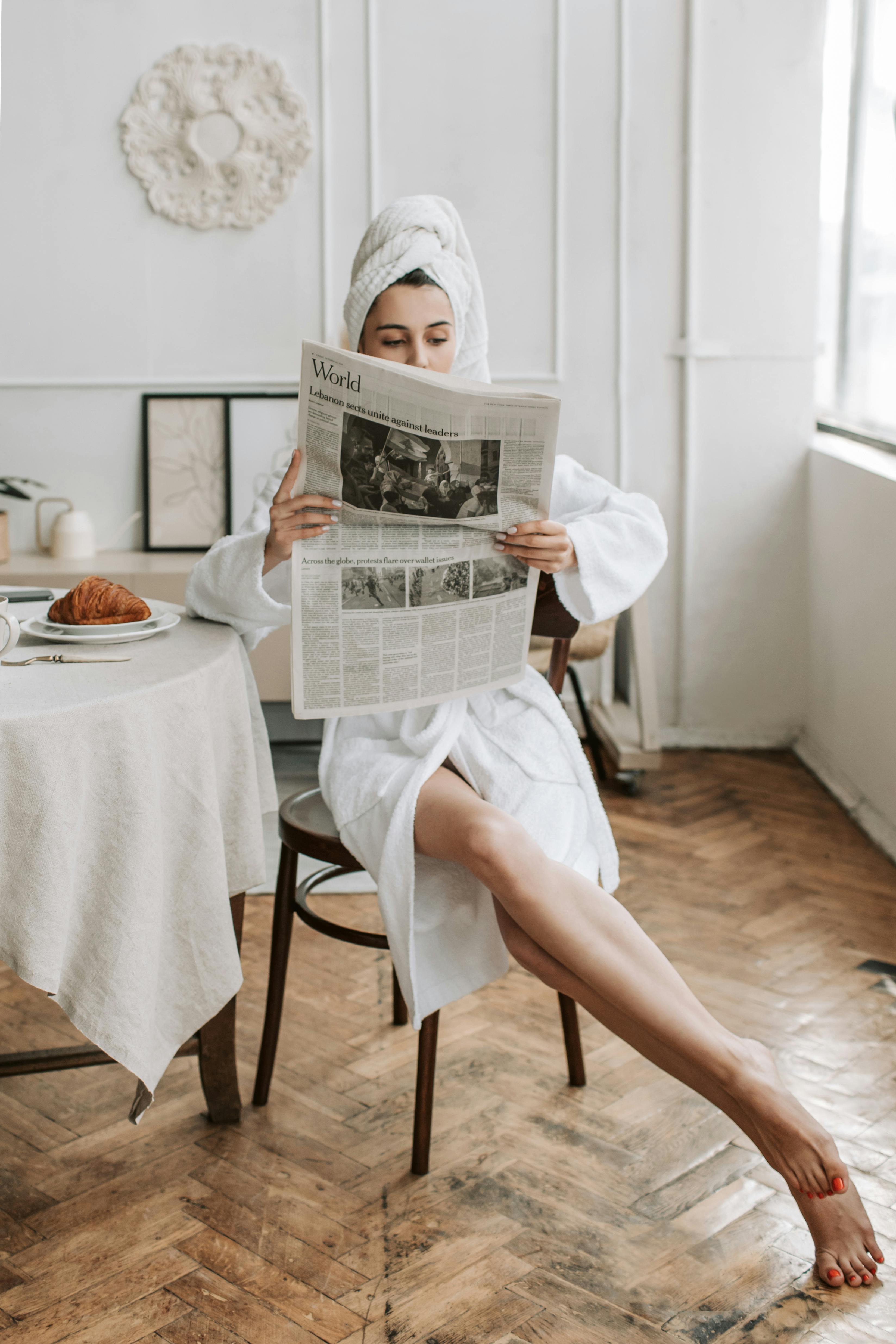 Une femme lisant un journal après avoir pris une douche | Source : Pexels