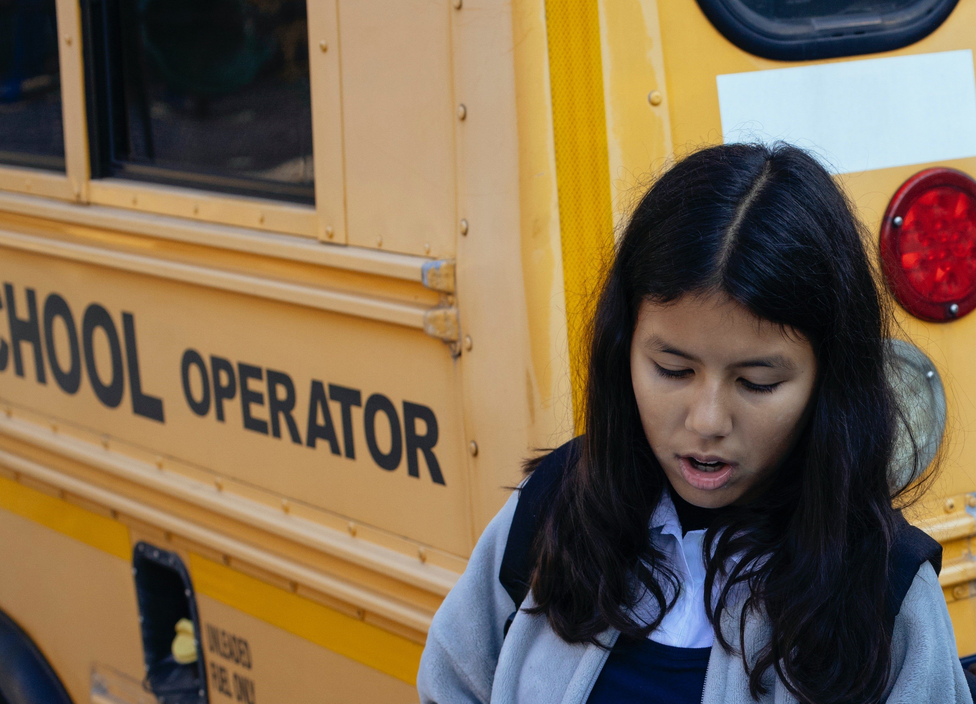 Une petite fille debout devant un bus | Source : Pexels
