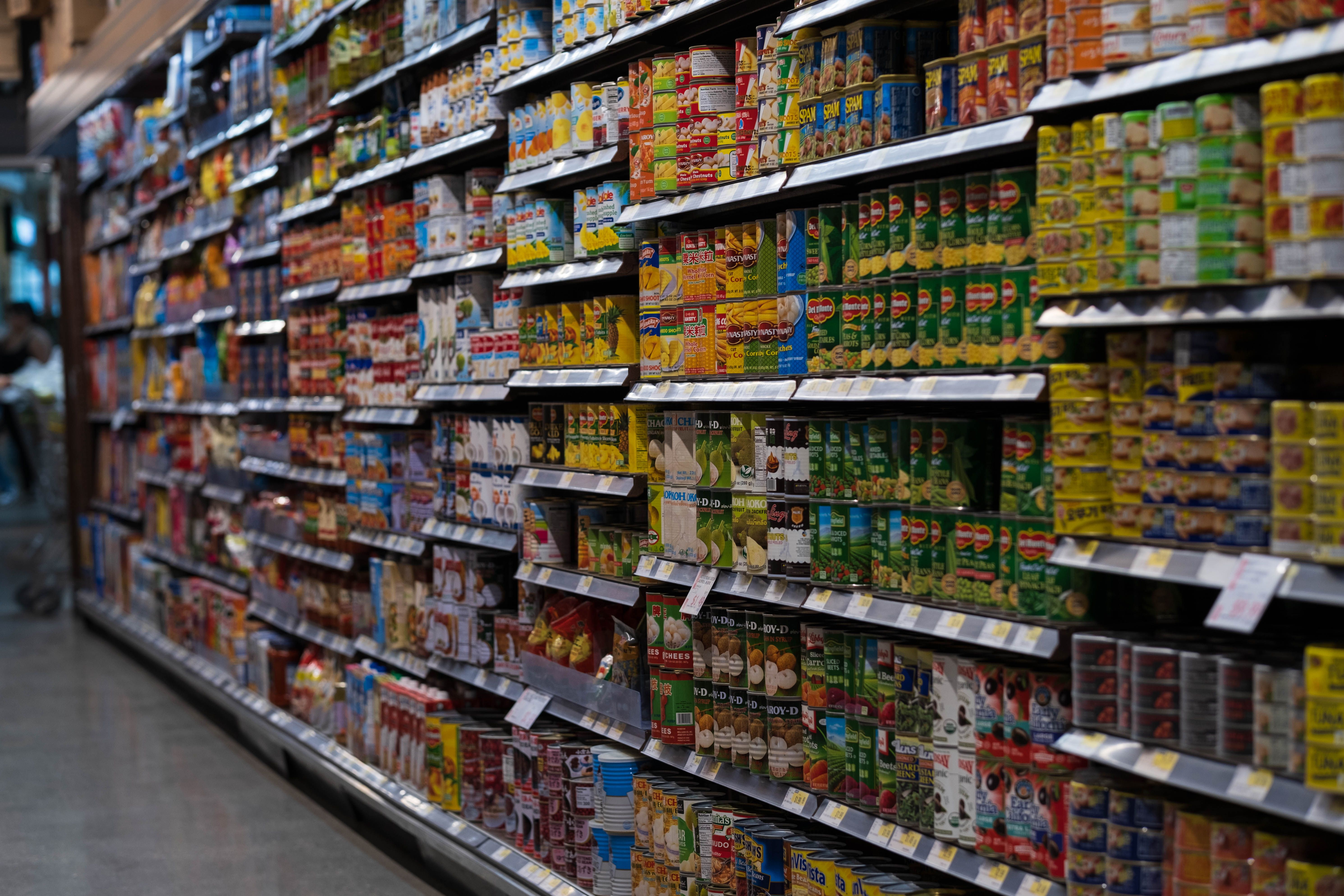 Une allée de supermarché bordée de rayons remplis d'une grande variété de conserves | Source : Pexels