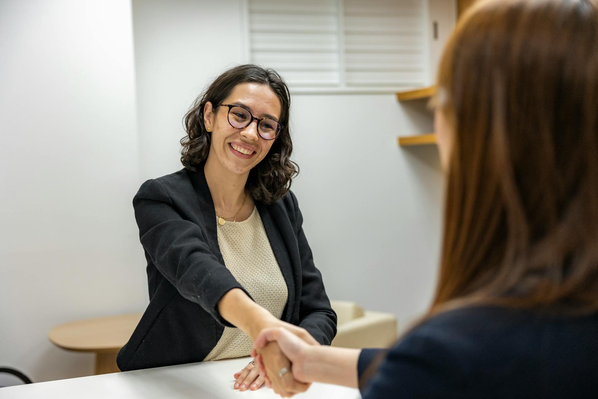 Femme se serrant la main dans un bureau | Source : Pexels