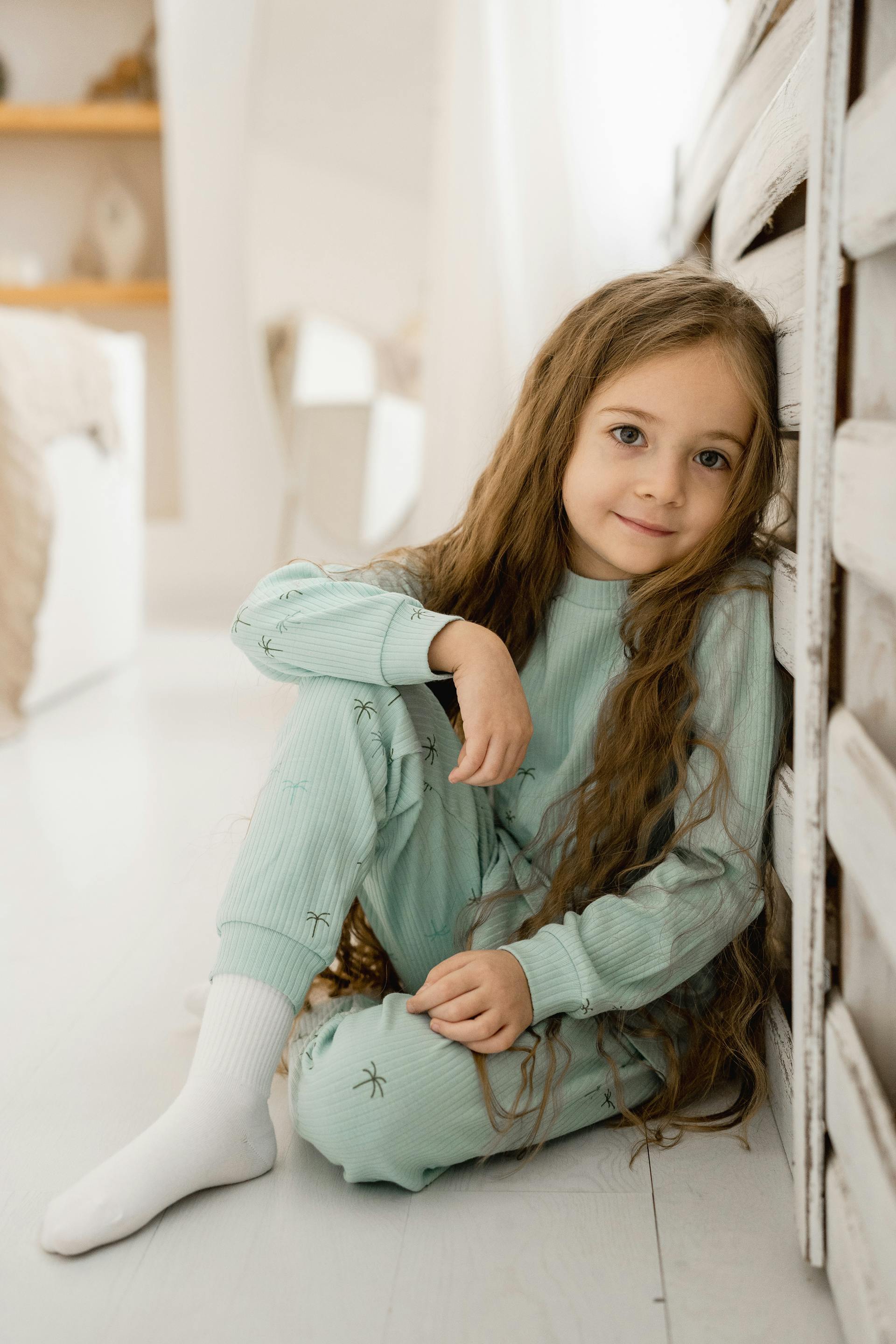 Une petite fille souriante aux cheveux longs | Source : Pexels