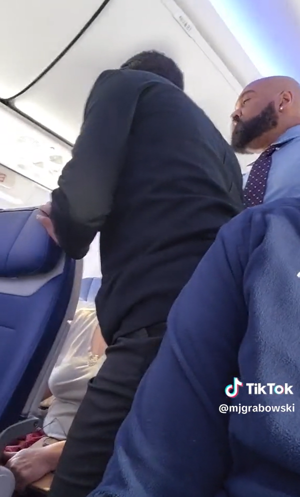 Un homme s'amuse à enregistrer un passager irrité qui se plaint des pleurs d'un bébé à bord d’un vol de Southwest Airlines, tandis que le personnel de bord tente de le calmer | Source : TikTok/mjgrabowski