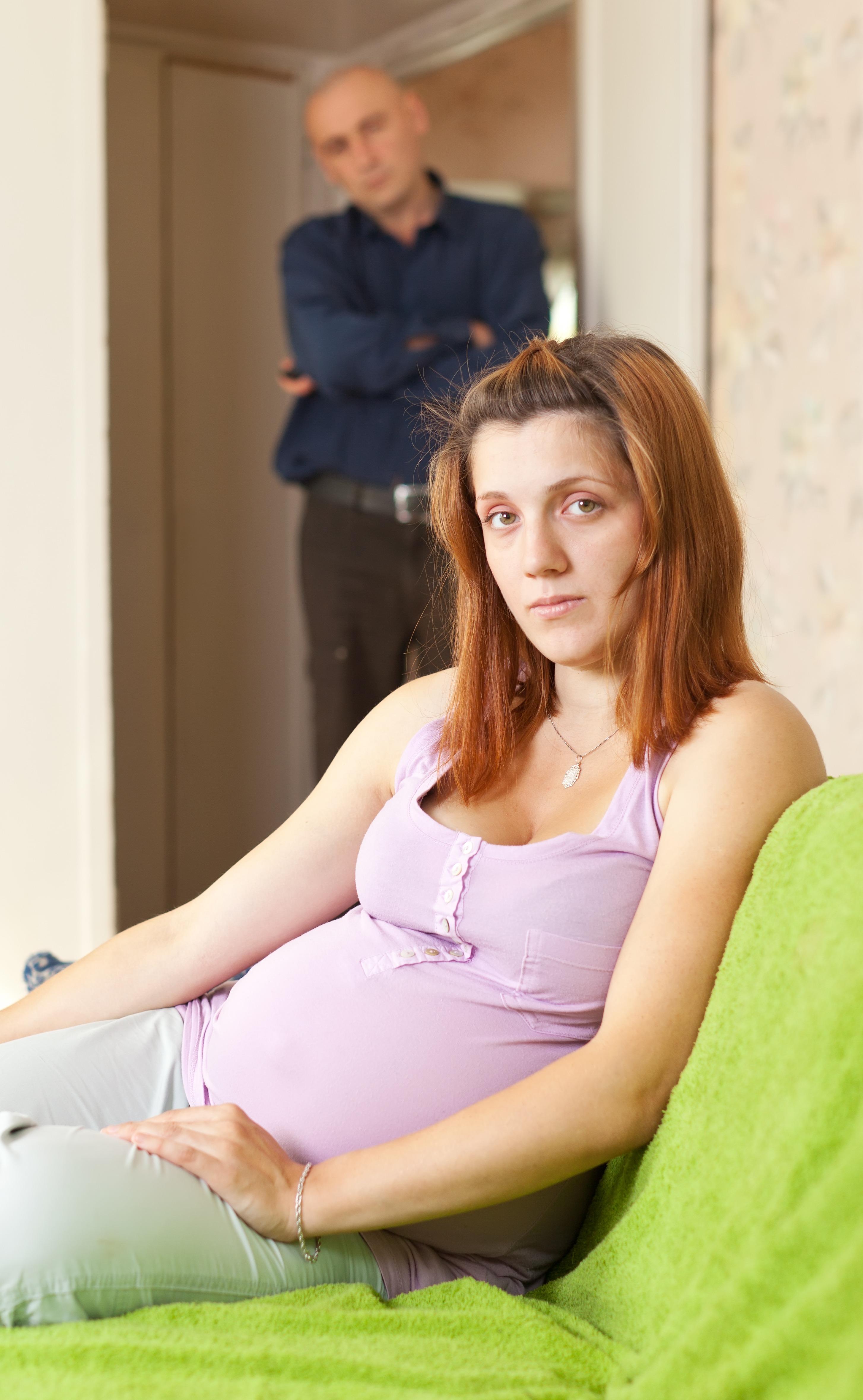 Une femme enceinte avec un homme se tenant derrière elle | Source : Shutterstock
