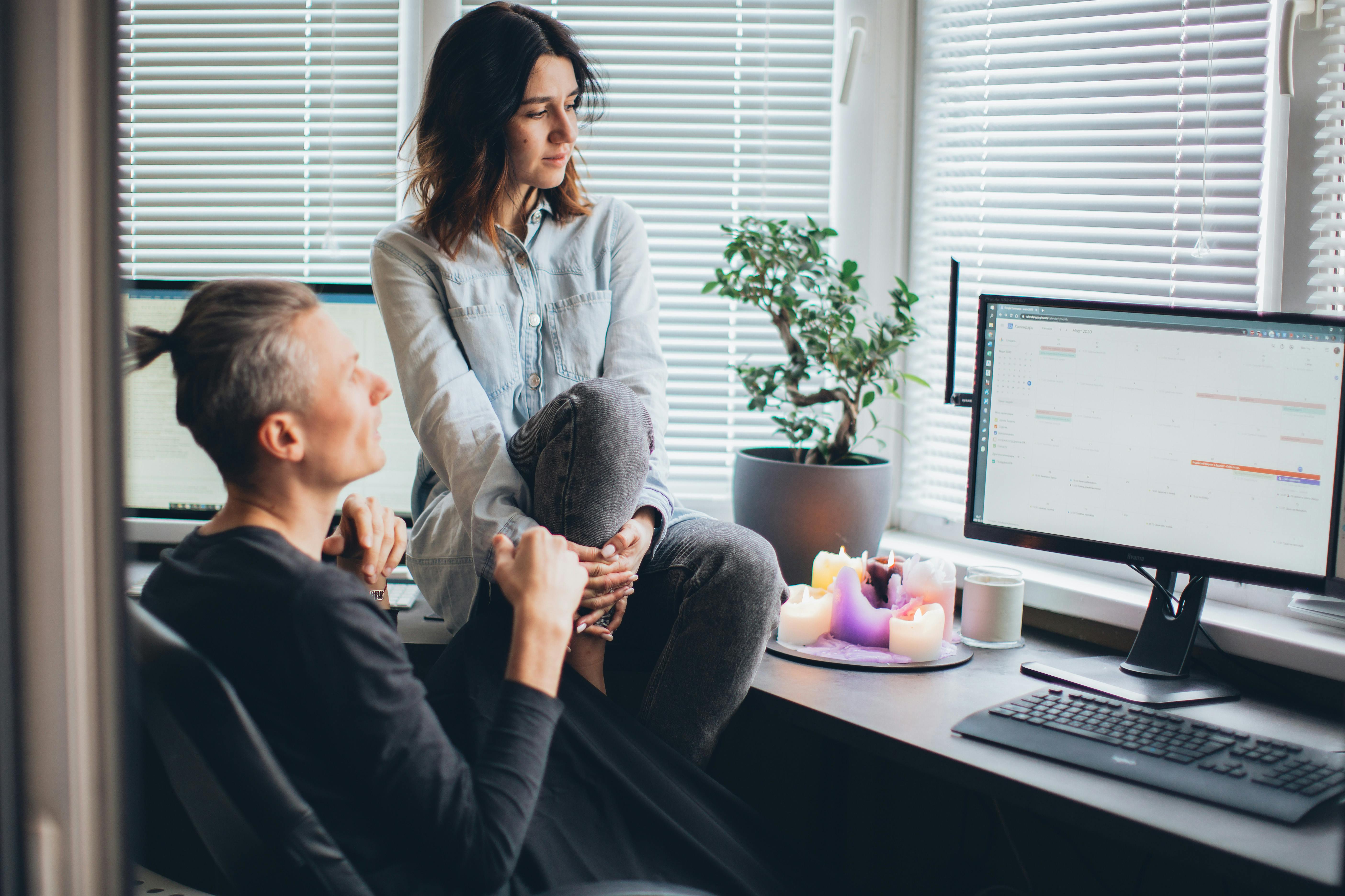 Homme avec une femme assise sur un bureau | Source : Pexels