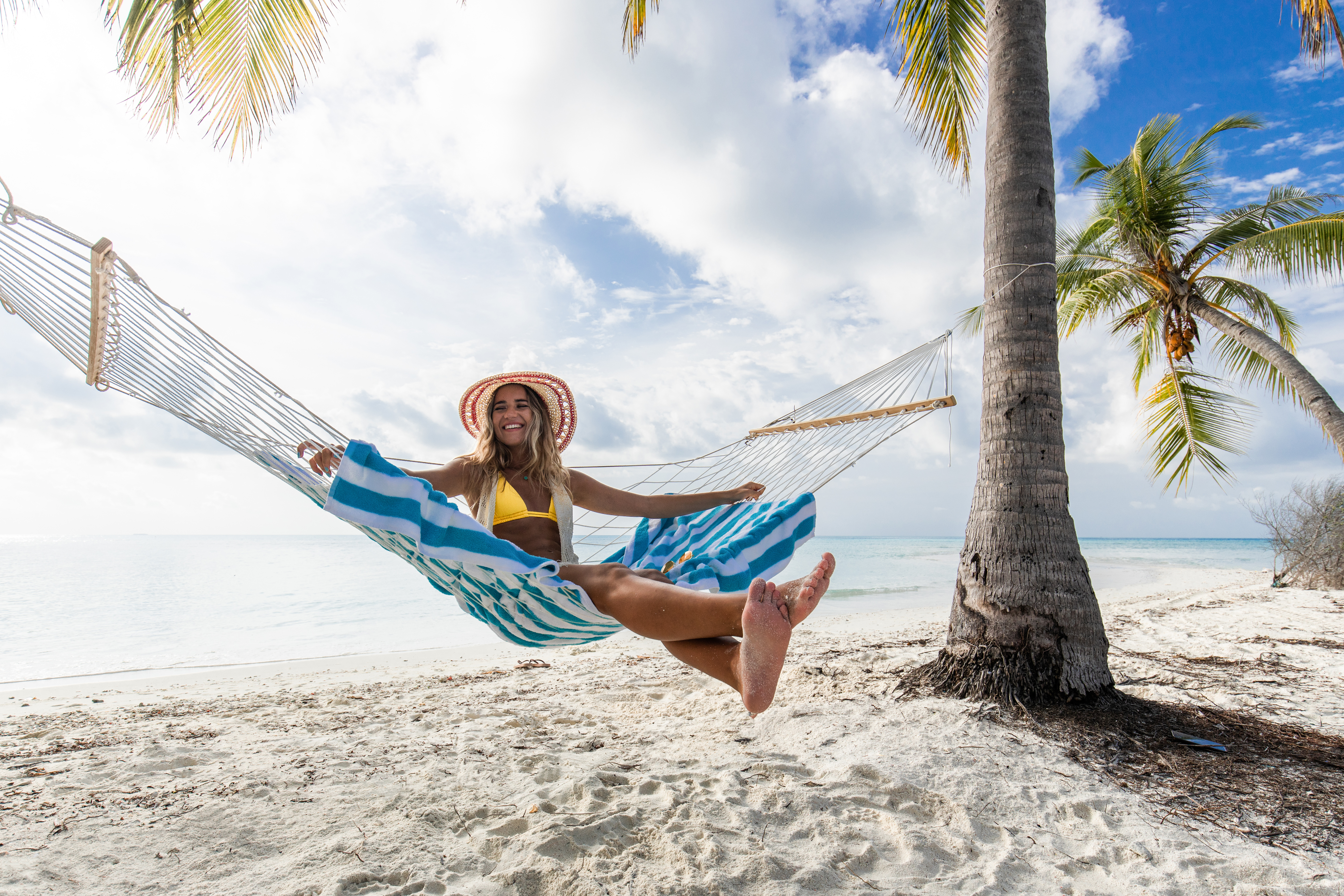 Jeune femme heureuse s'amusant dans un hamac sur la plage | Source : Getty Images