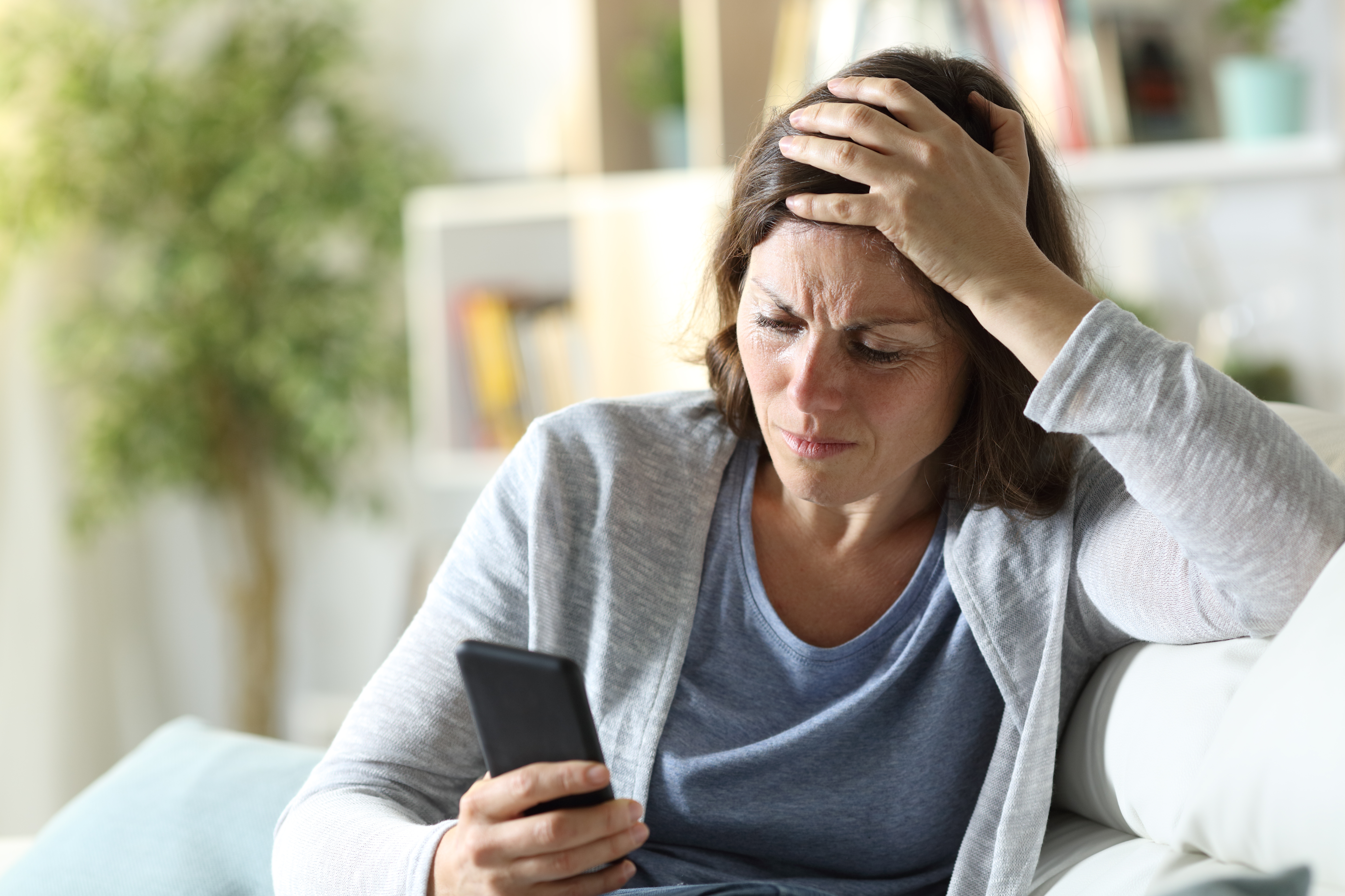 Une femme à l'air confus et triste en regardant son téléphone | Source : Shutterstock