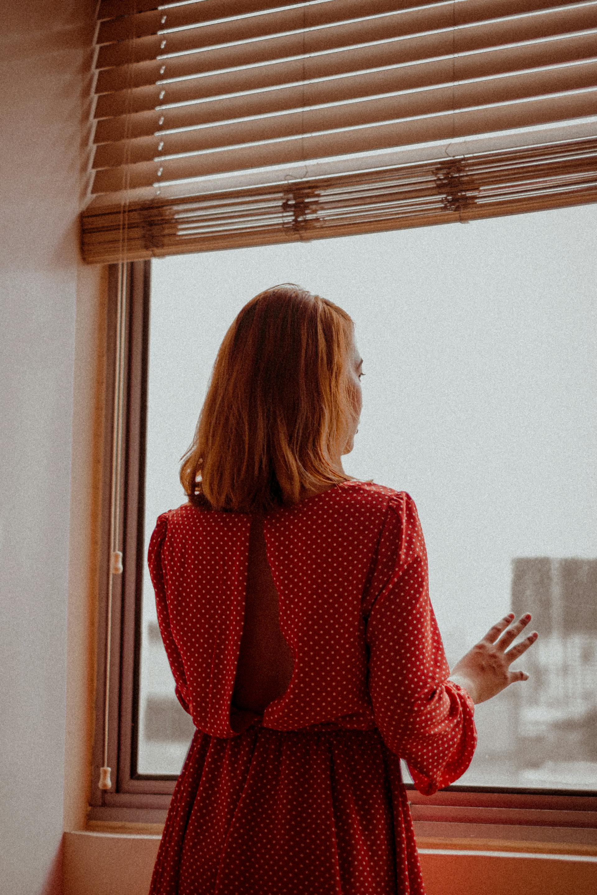 Une femme qui regarde par la fenêtre | Source : Pexels