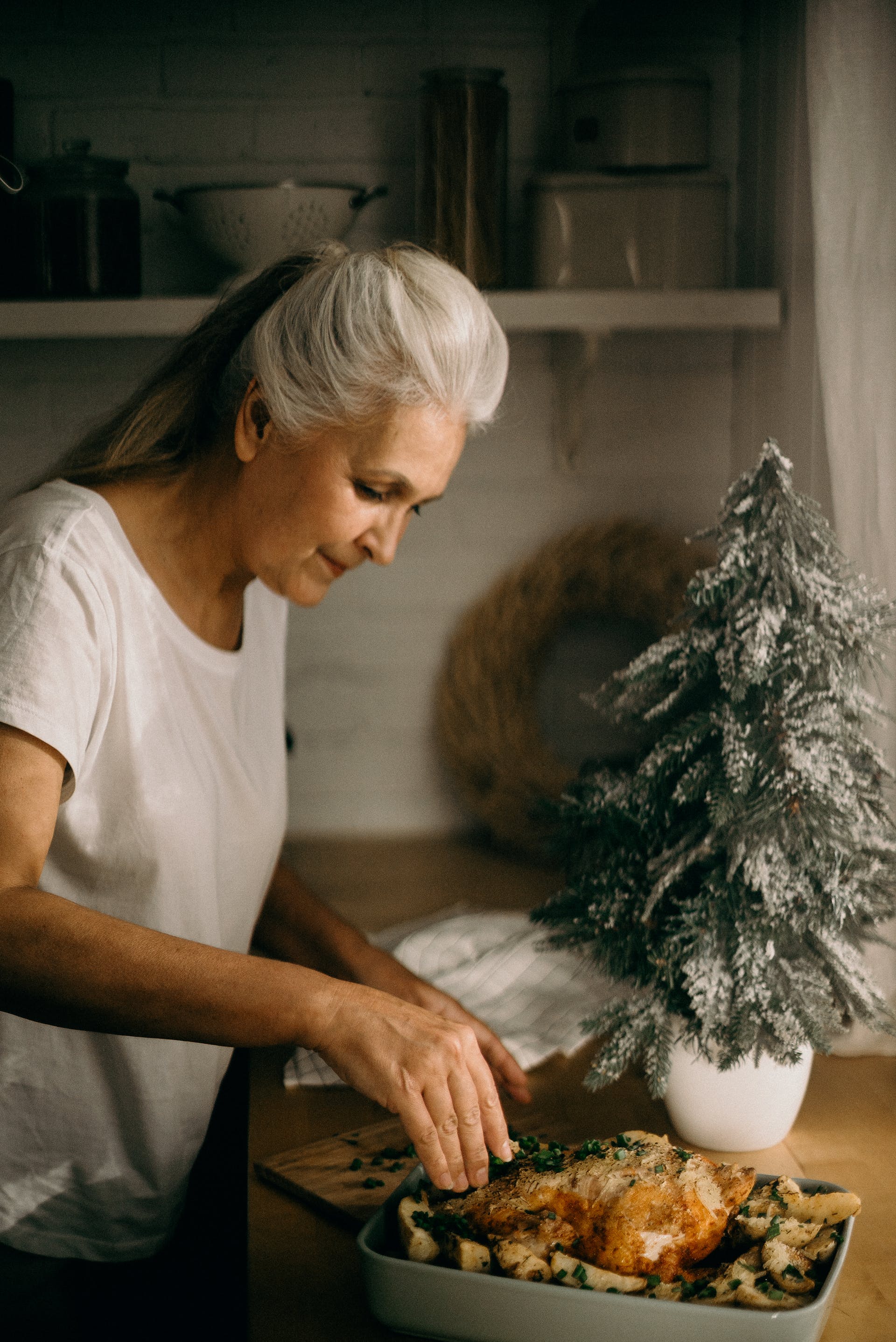 Une femme âgée debout dans la cuisine devant un plat | Source : Pexels