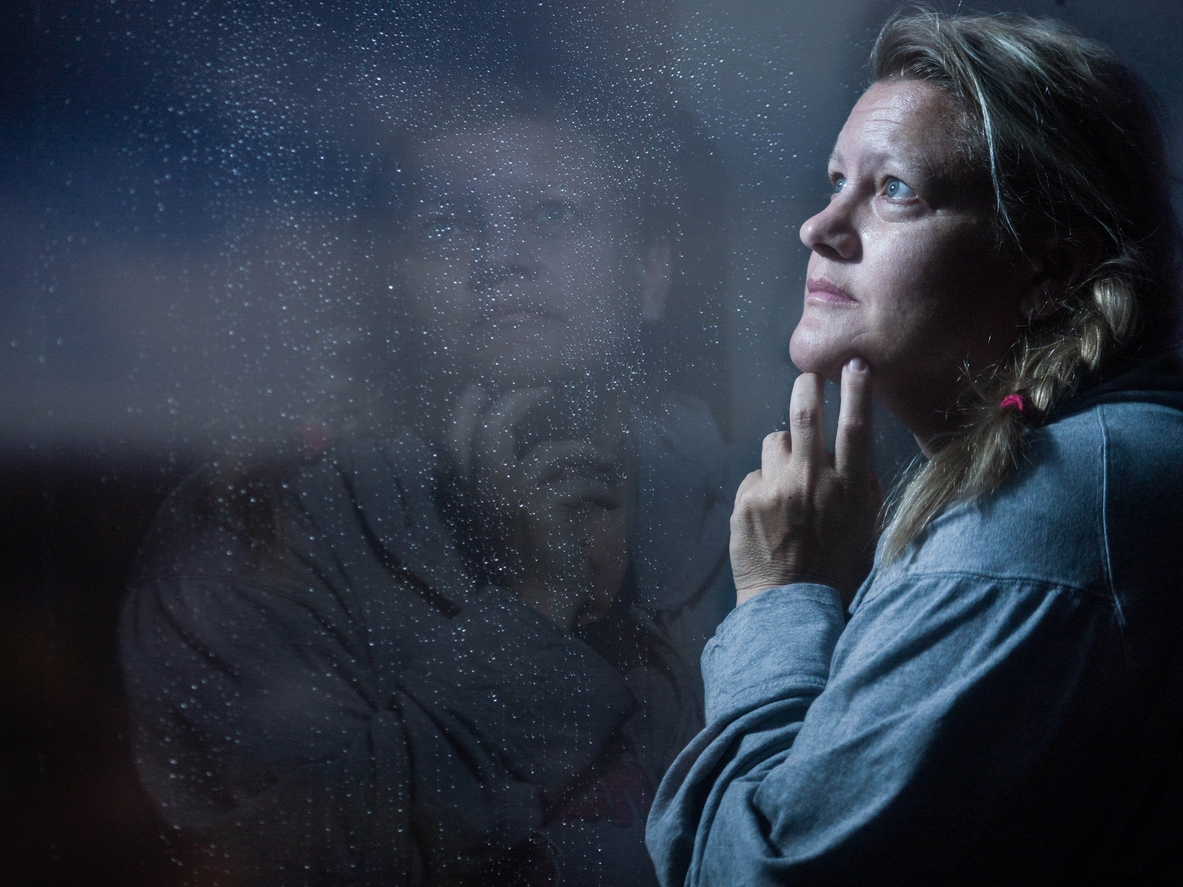 Une femme qui regarde à l'extérieur d'une fenêtre. | Source : Unsplash