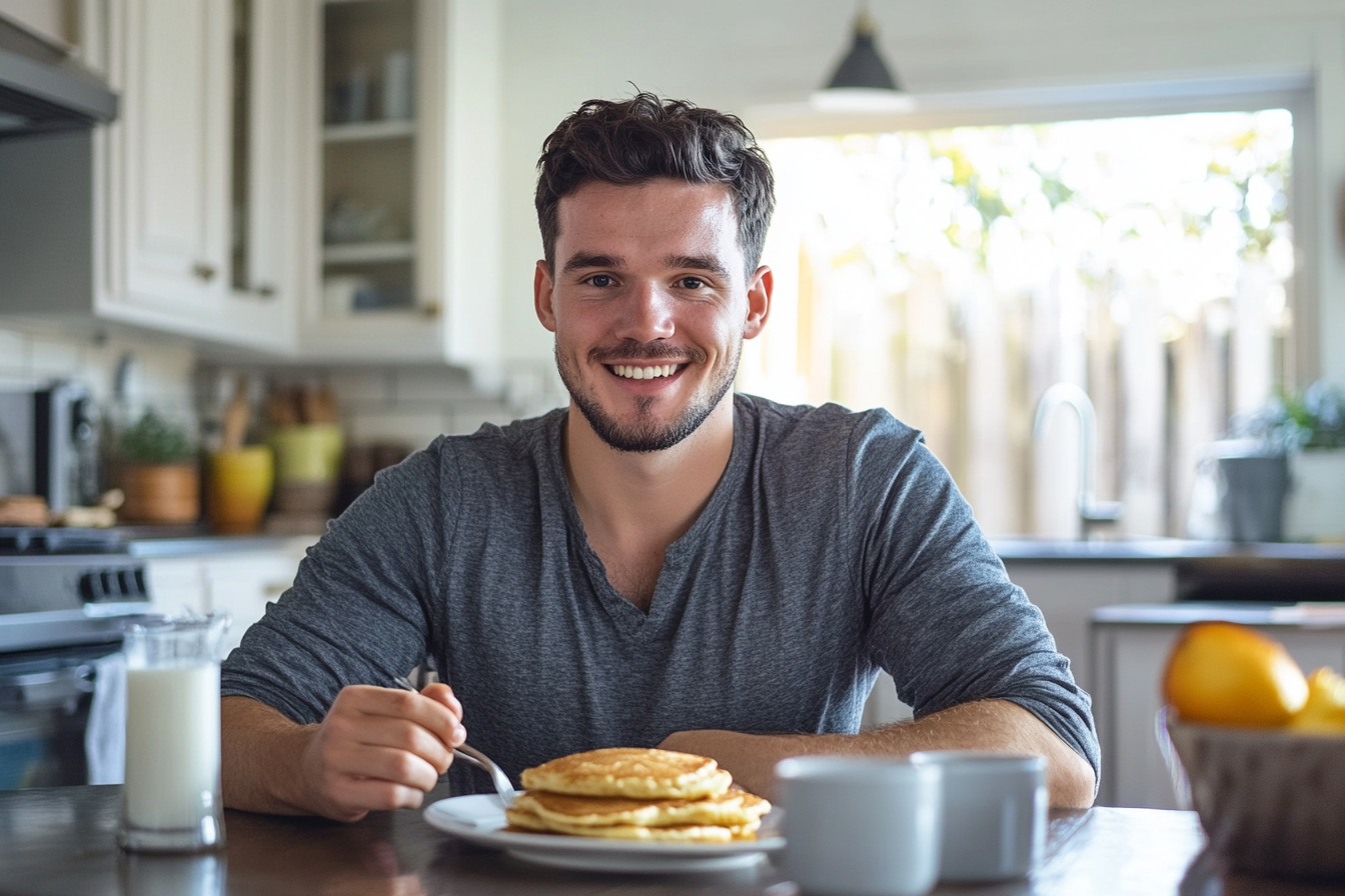Homme souriant en prenant son petit déjeuner | Source : Midjourney