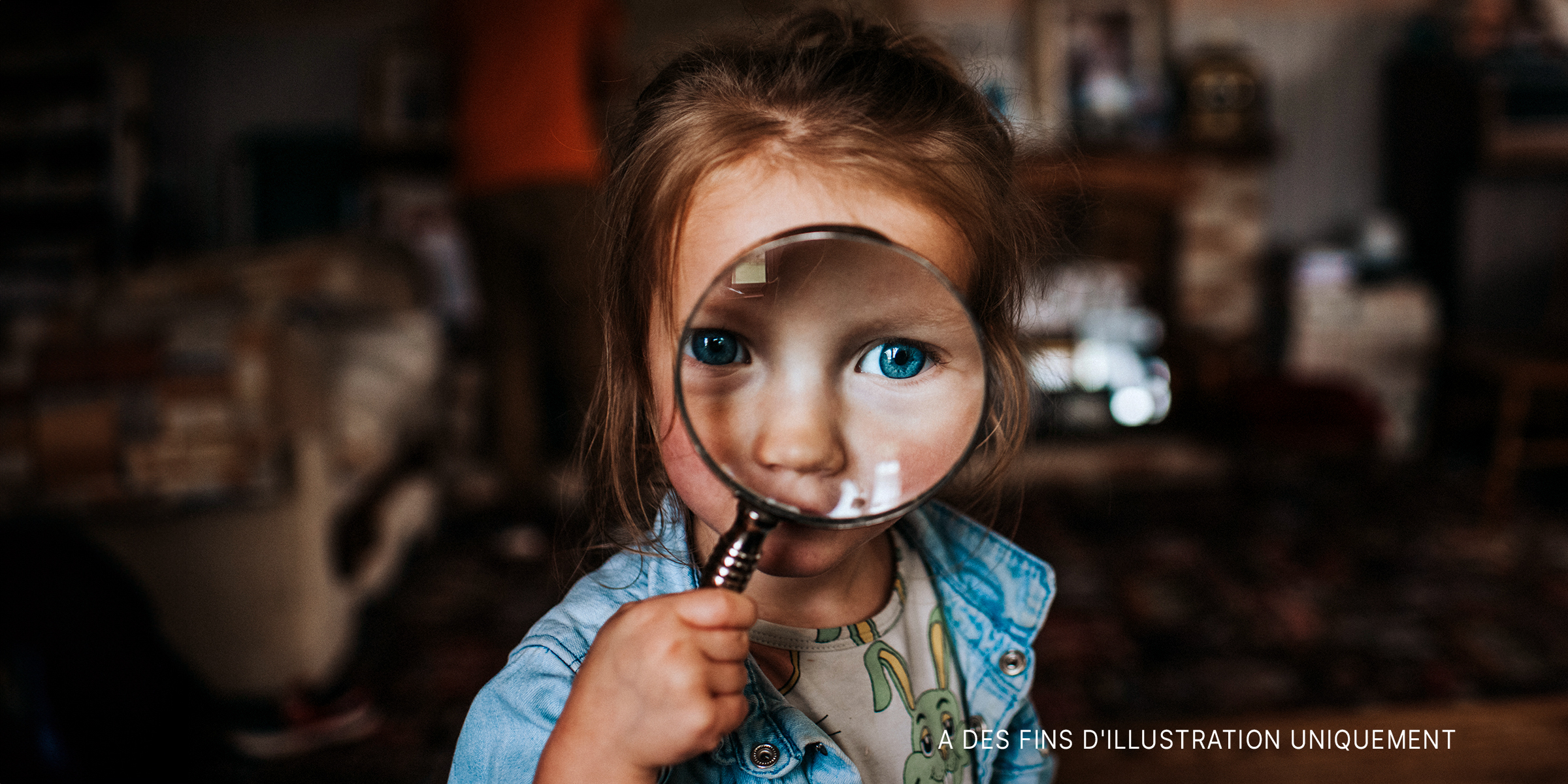 Une petite fille tenant une loupe | Source : Shutterstock