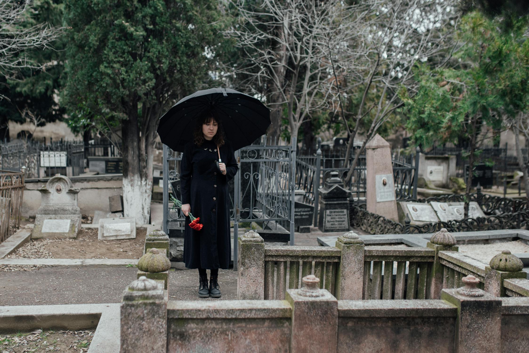 Une jeune femme debout au cimetière ⏐ Source : Pexels