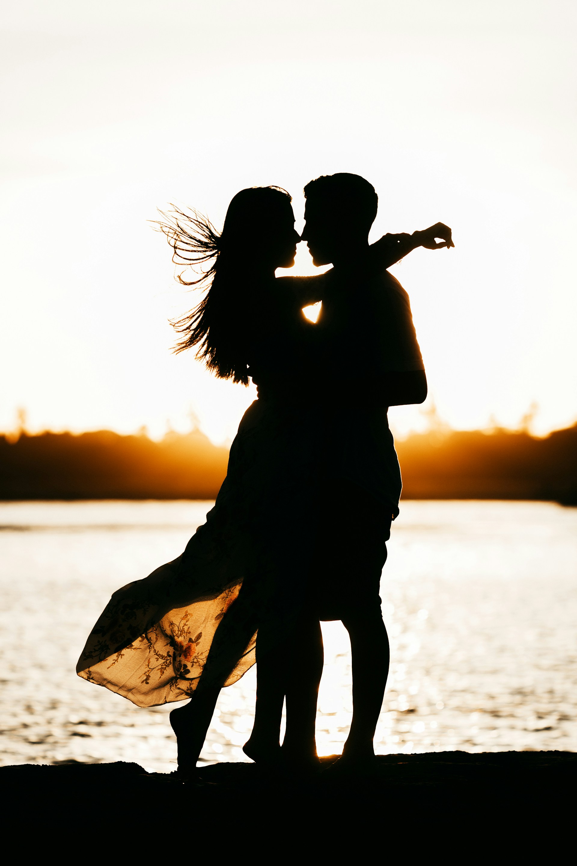 Silhouette d'un couple romantique au bord de la mer | Source : Unsplash