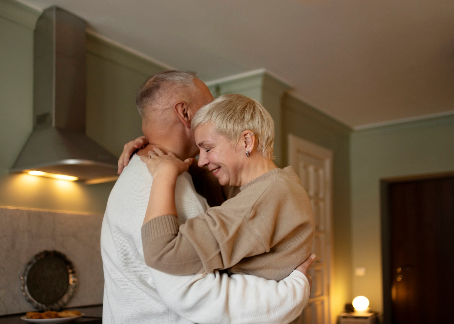 Un couple de seniors s'embrassant dans la cuisine | Source : Freepik
