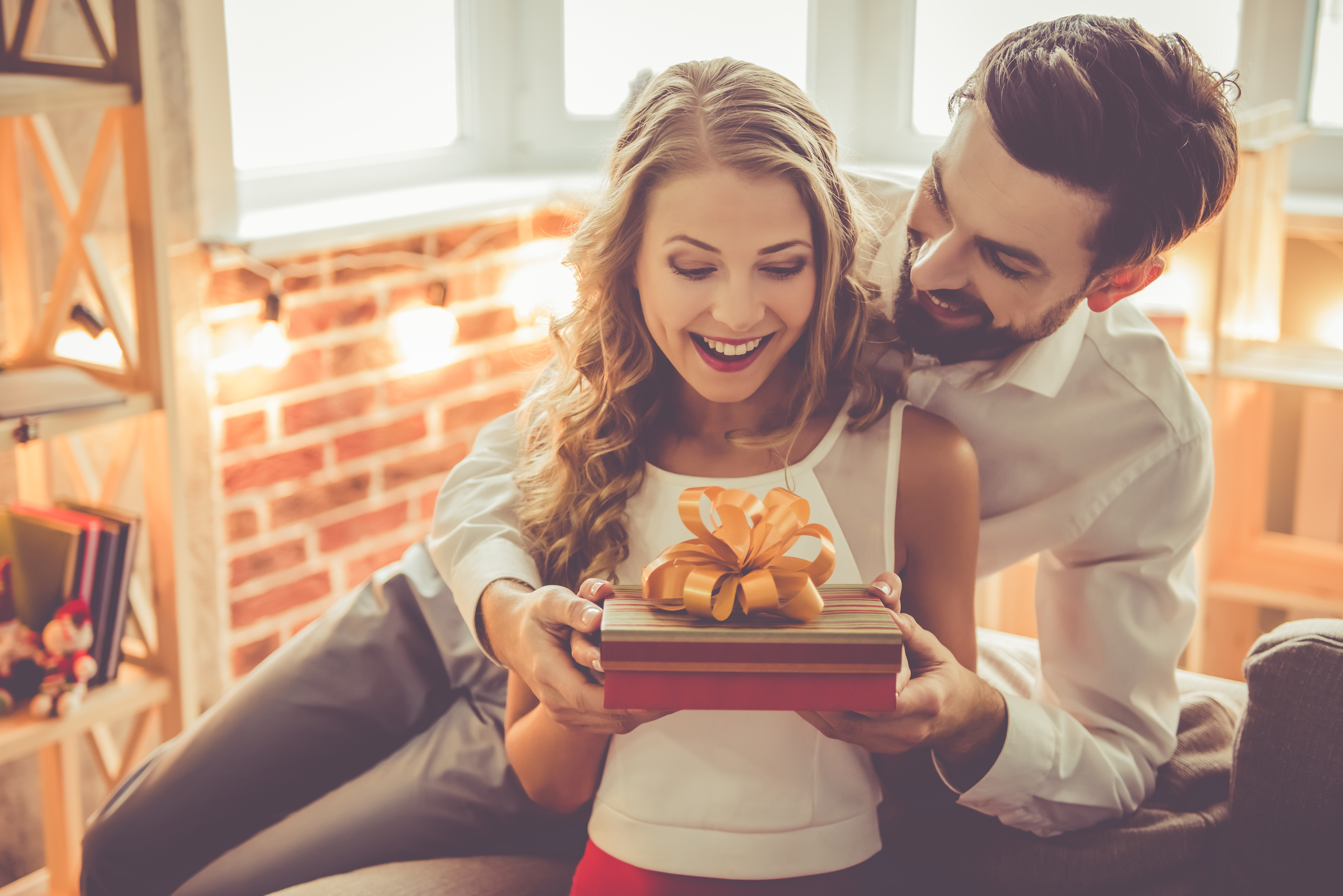 Un jeune homme offrant un coffret cadeau à sa petite amie | Source : Shutterstock
