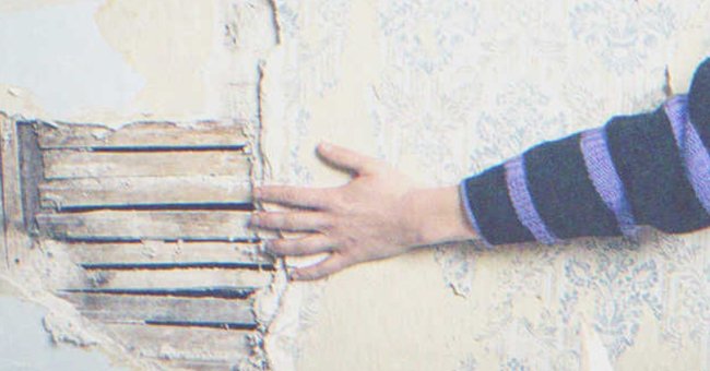 Main d'une personne touchant un vieux mur | Source : Shutterstock