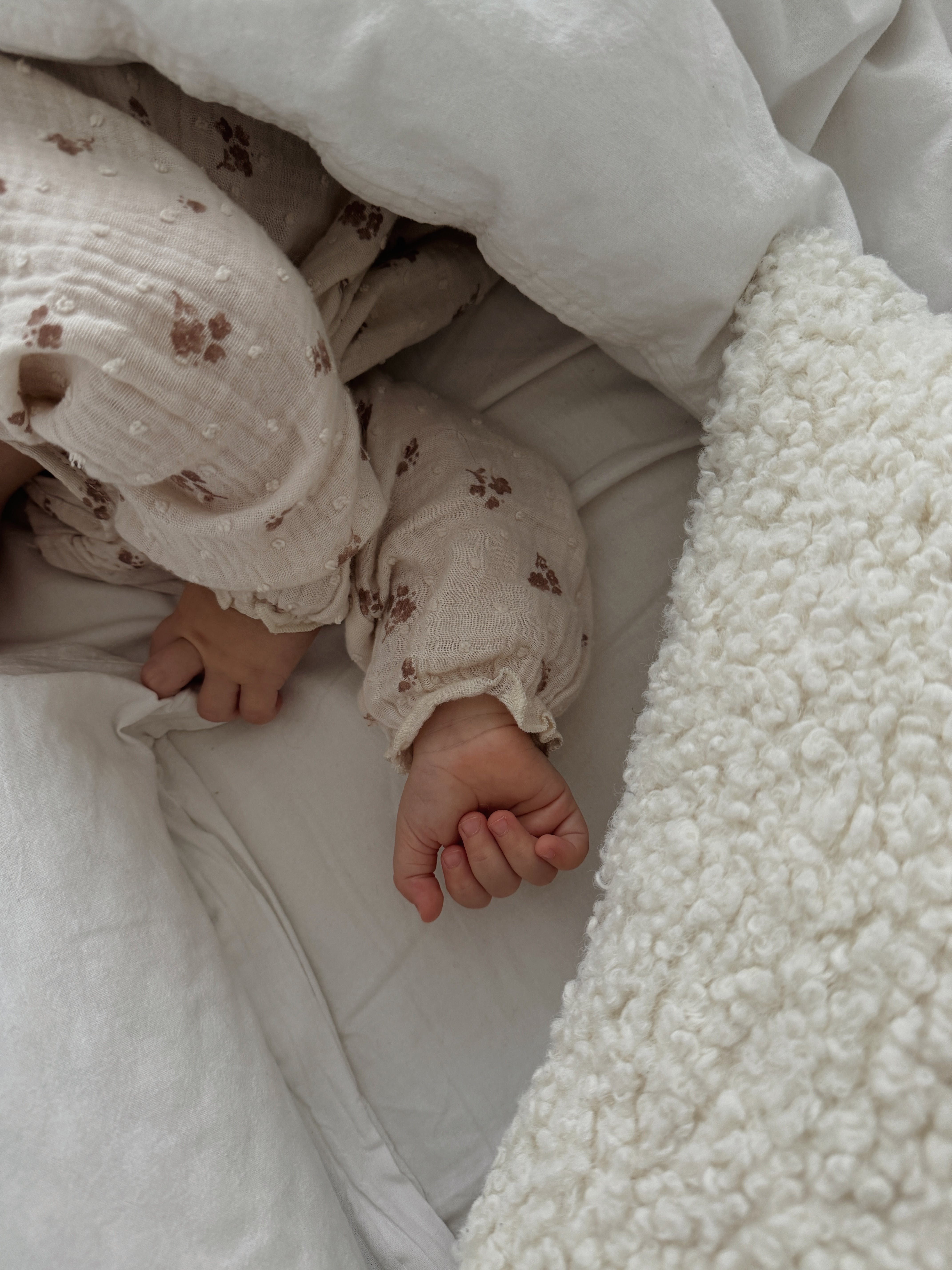 Les mains d'un bébé vues alors qu'il dort dans un lit d'enfant | Source : Pexels