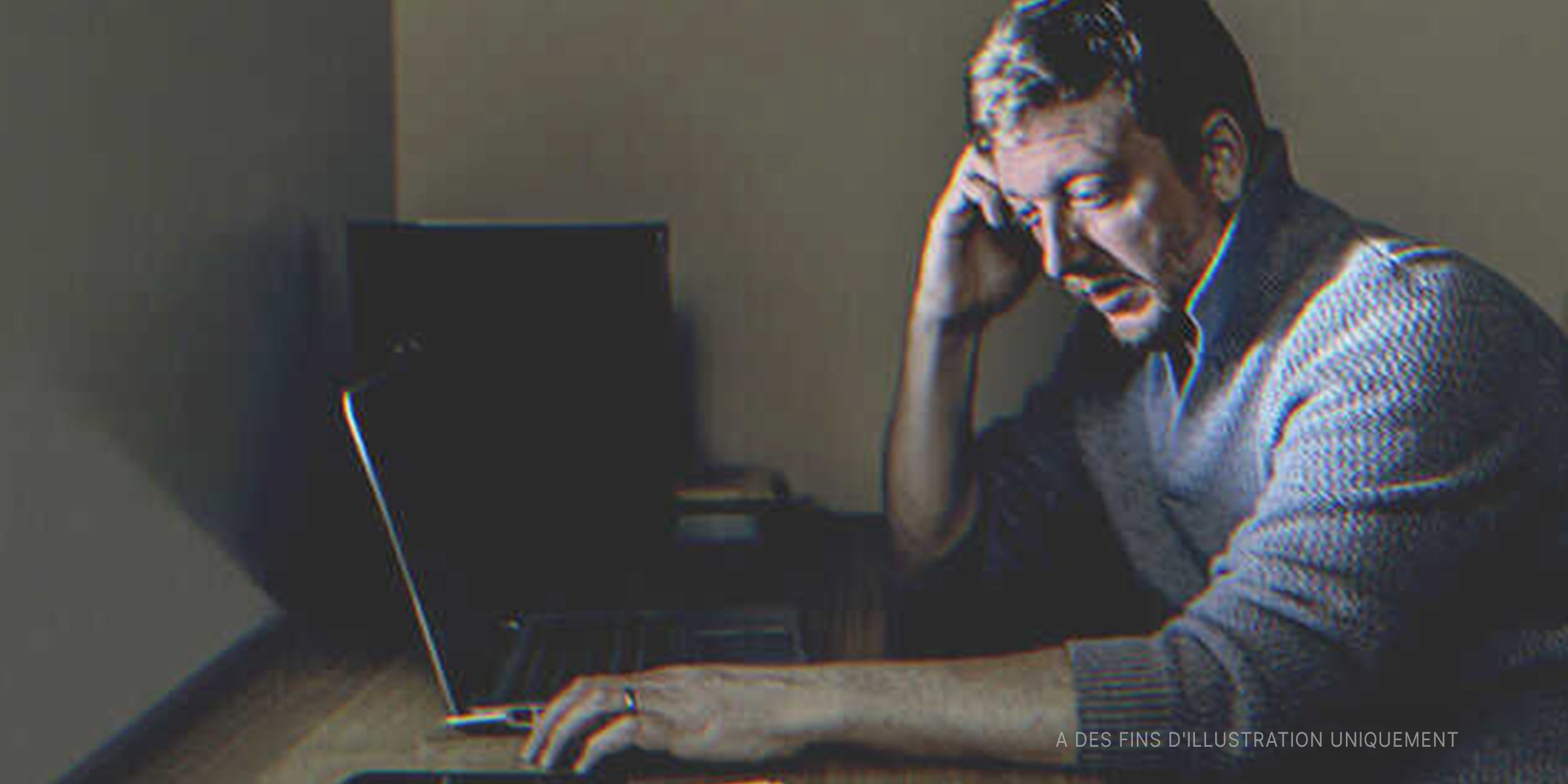 Un homme triste assis devant un ordinateur portable | Source : Getty Images