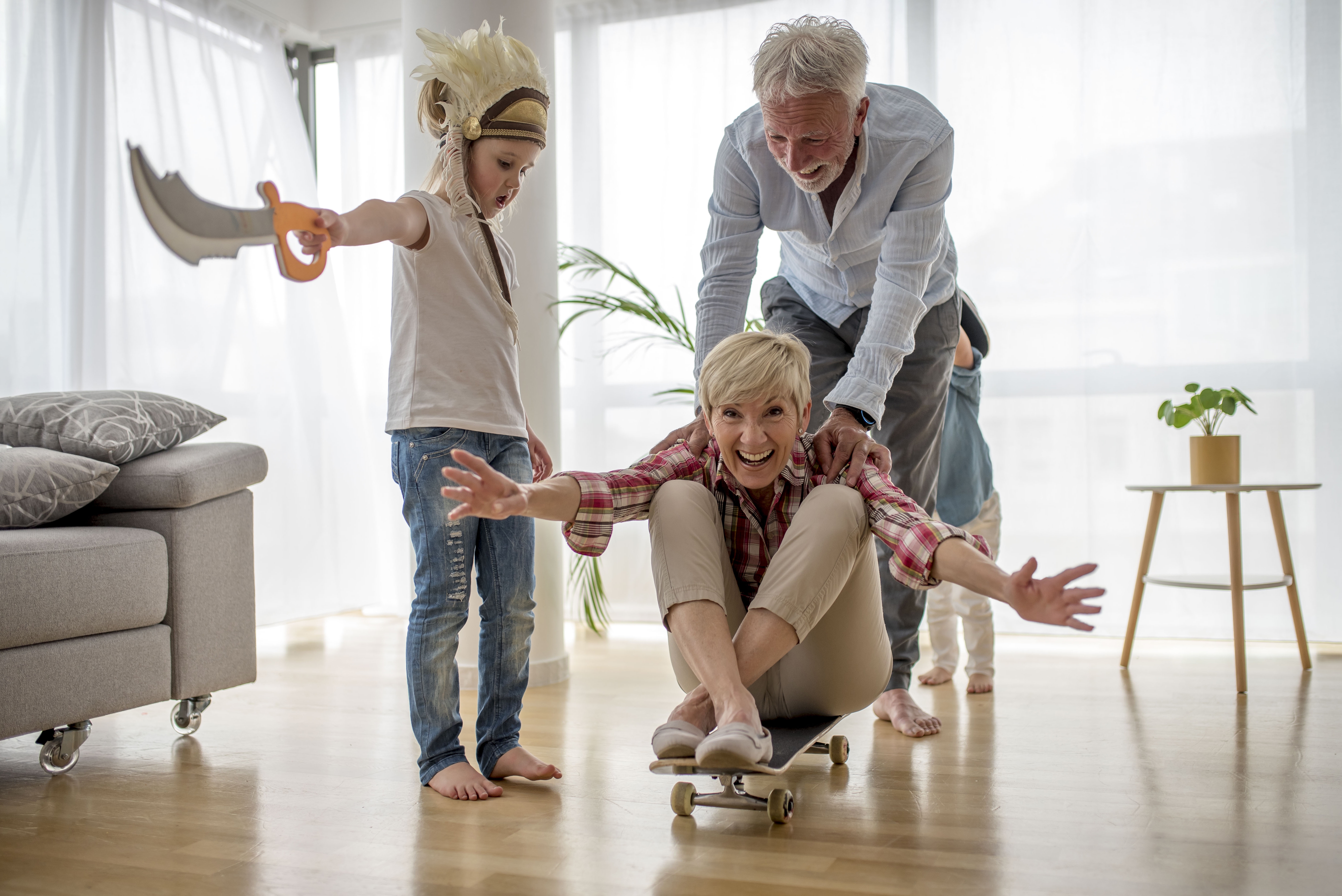 Une grand-mère assise sur un skateboard alors que son mari la pousse et que son petit-fils regarde | Source : Freepik