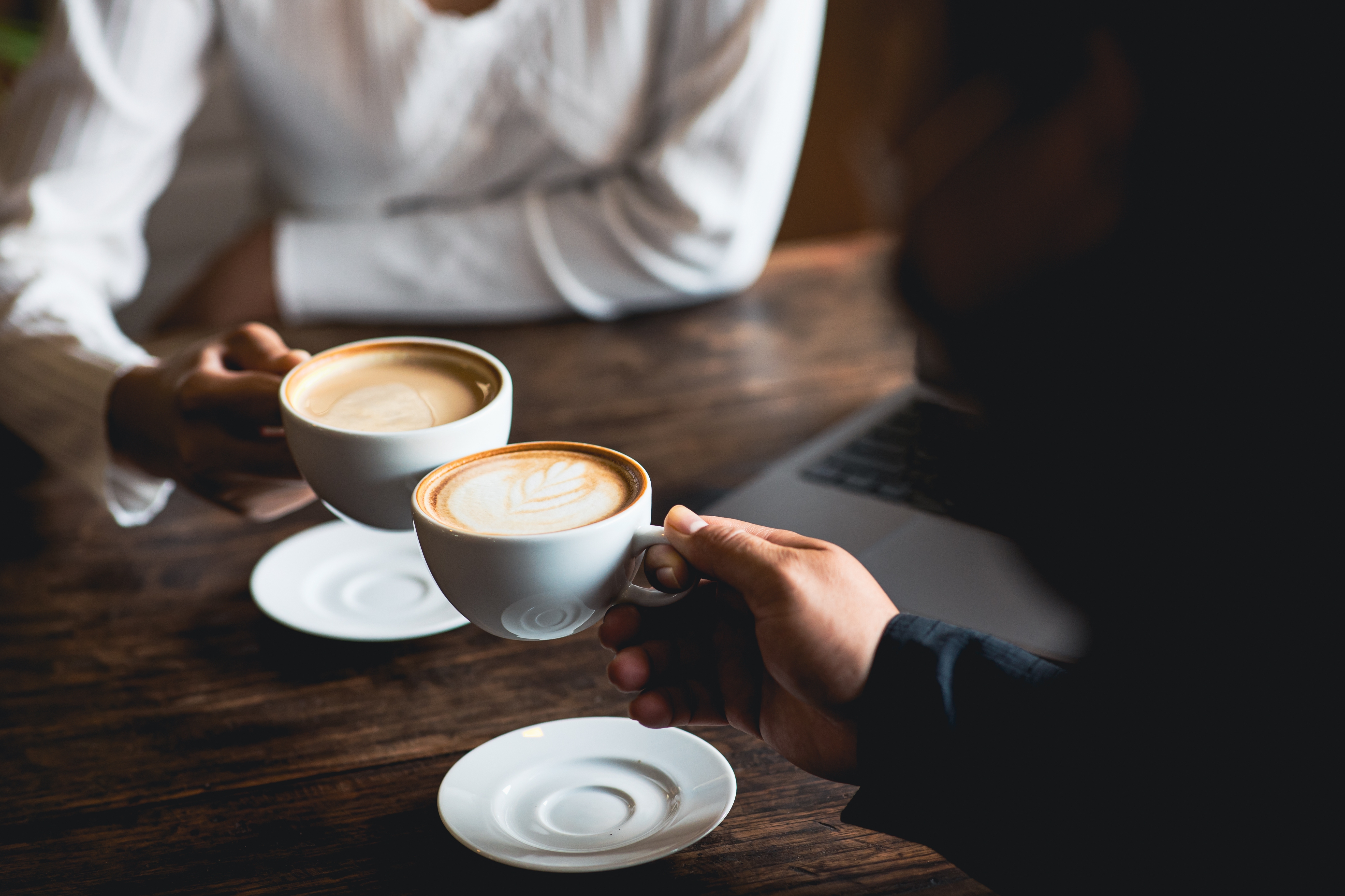 Gros plan d'un homme et d'une femme prenant des cafés dans un restaurant | Source : Shutterstock
