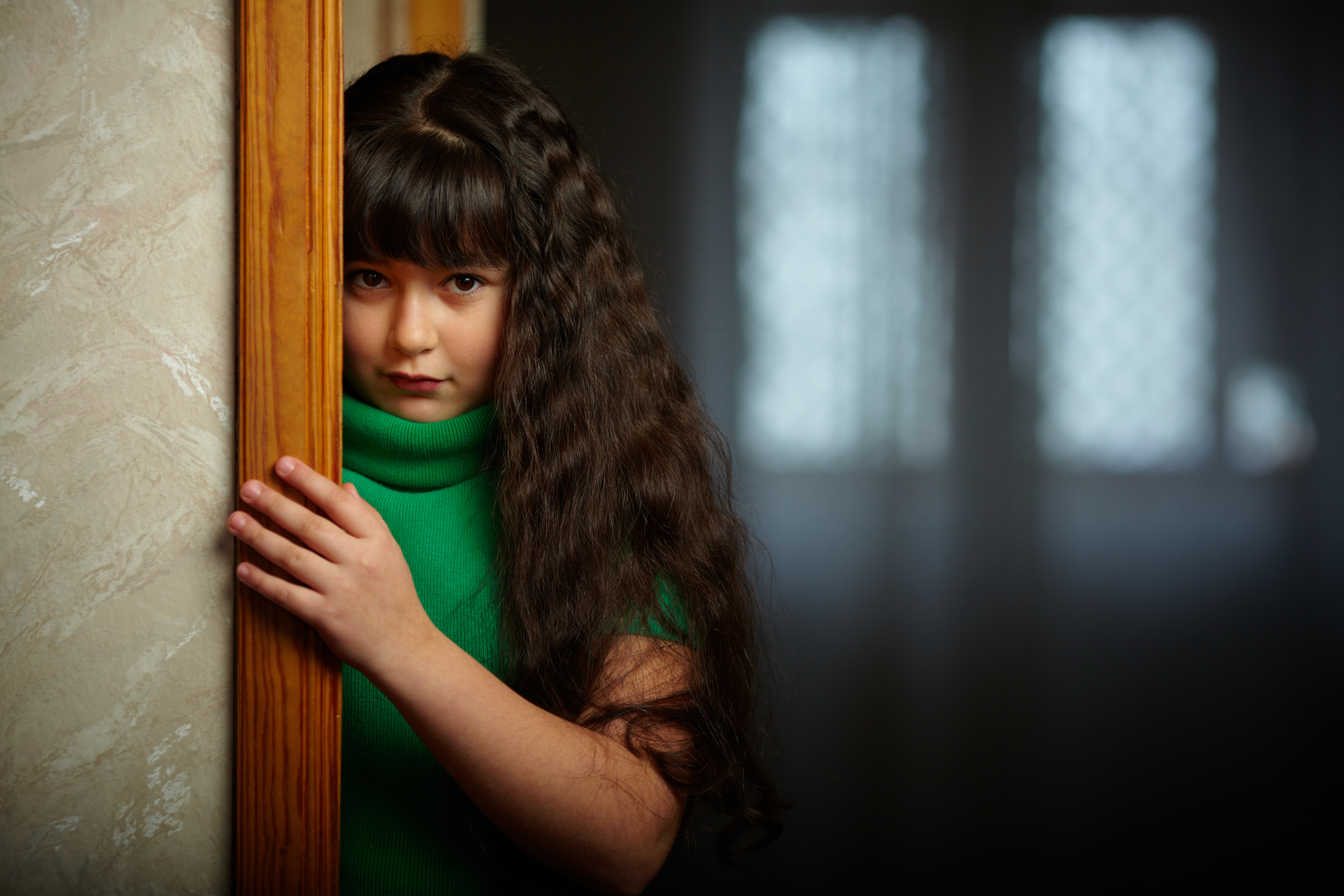 Menina triste perto da porta |  Fonte: Shutterstock.com