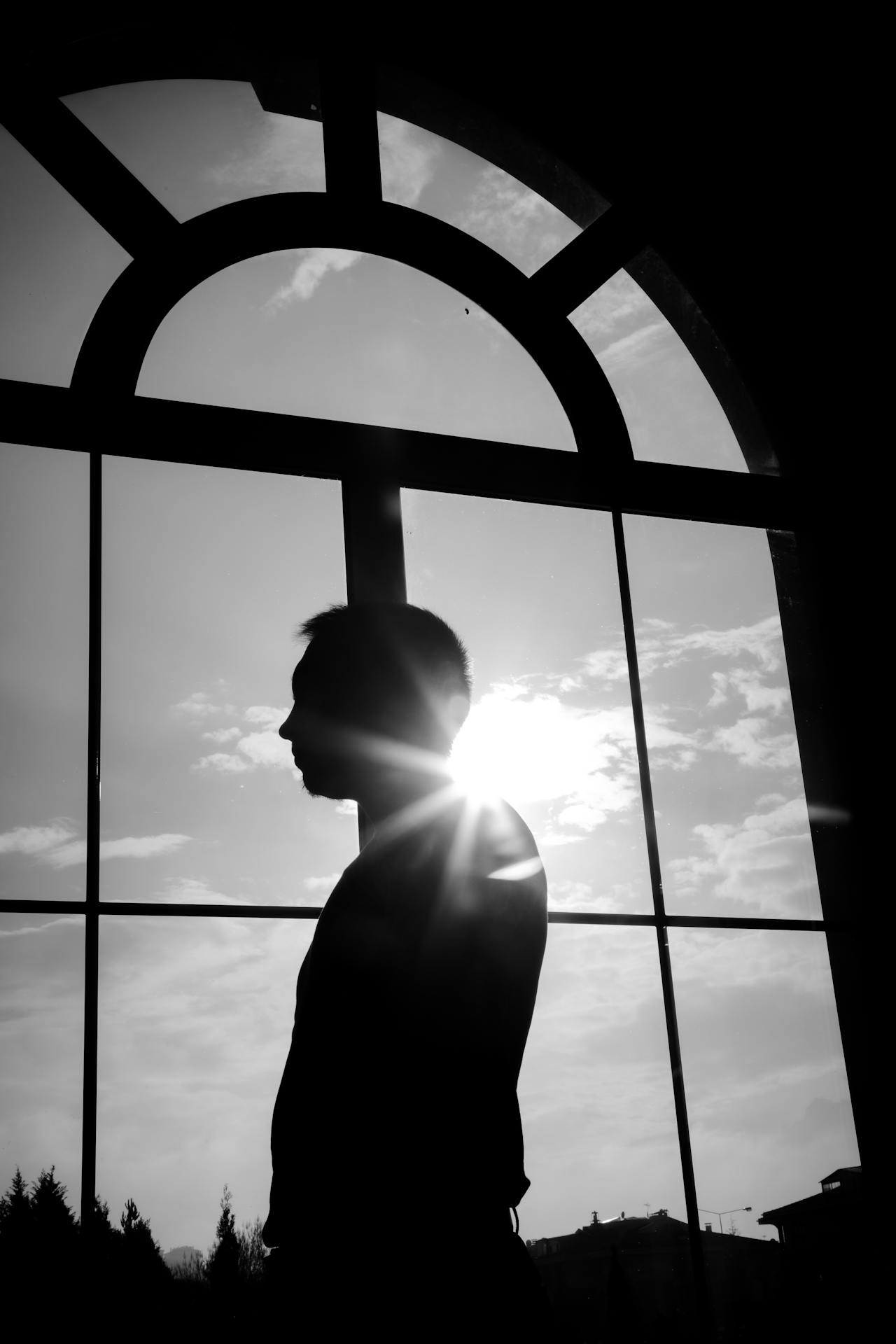 Un homme debout près d'une fenêtre cintrée | Source : Pexels