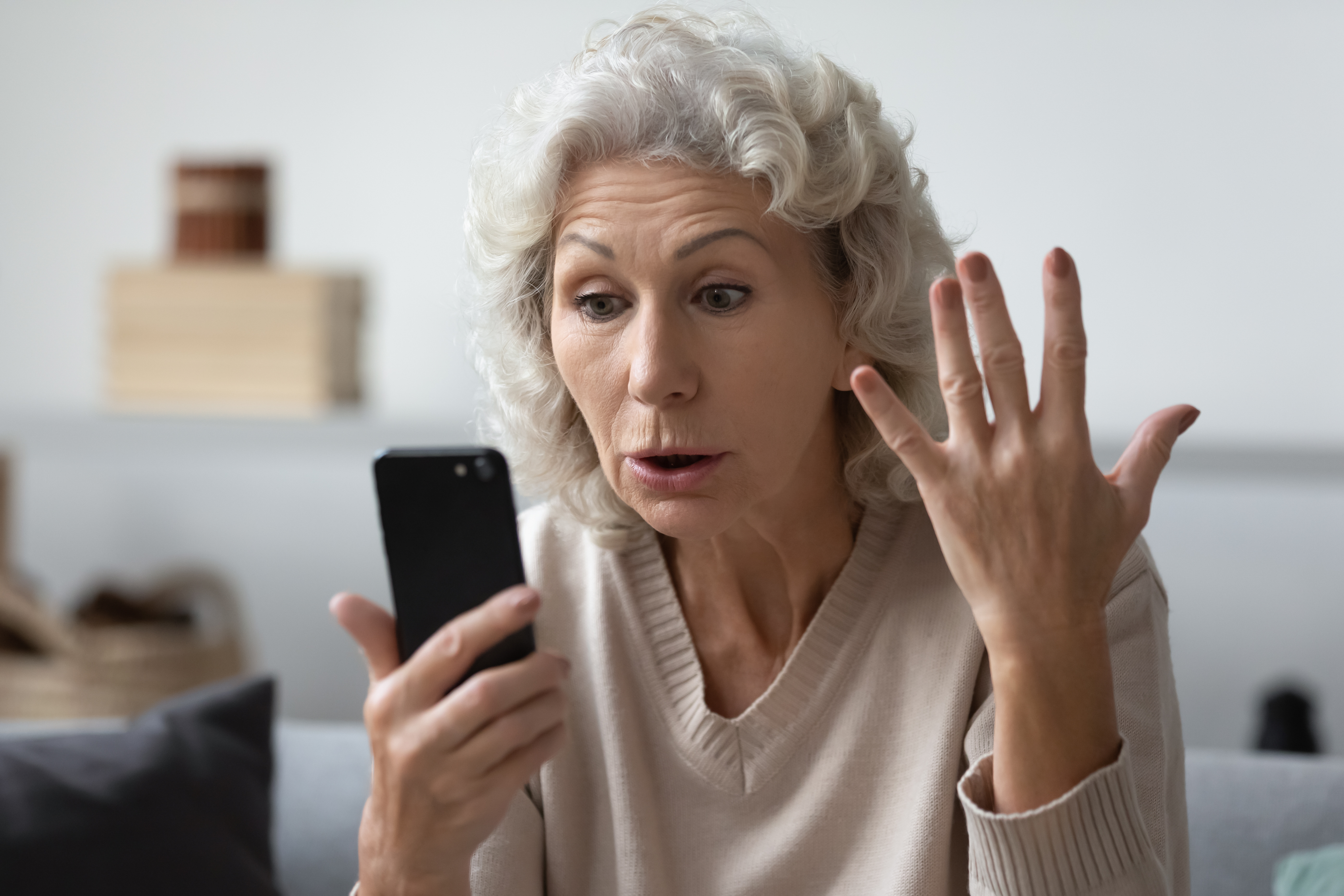 Une personne âgée lisant quelque chose sur son téléphone. | Source : Shutterstock/fizkes