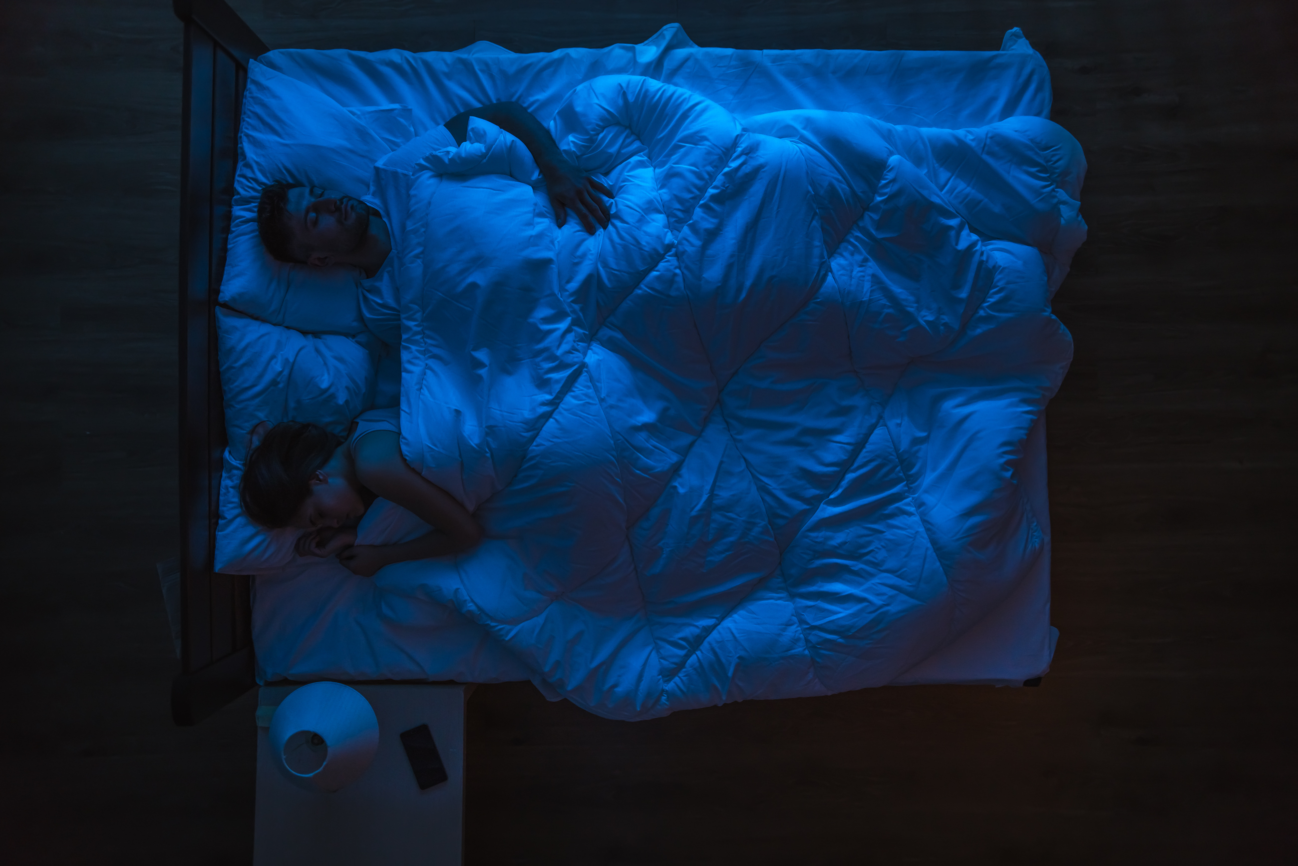 Le couple dormant sur un lit. Le soir, à l'heure de la nuit. | Source : Shutterstock