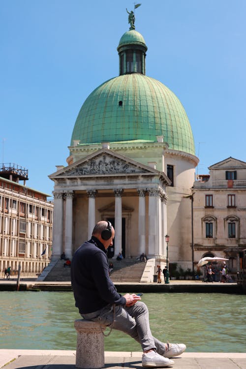 Un homme assis au bord du canal | Source : Pexels