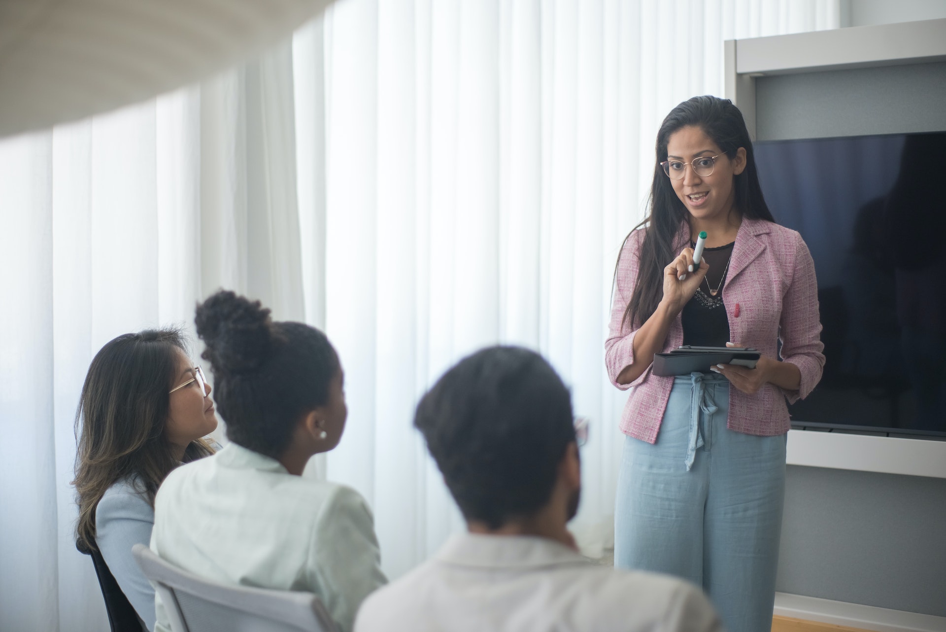 Una mujer haciendo una presentación delante de la gente | Fuente: Pexels