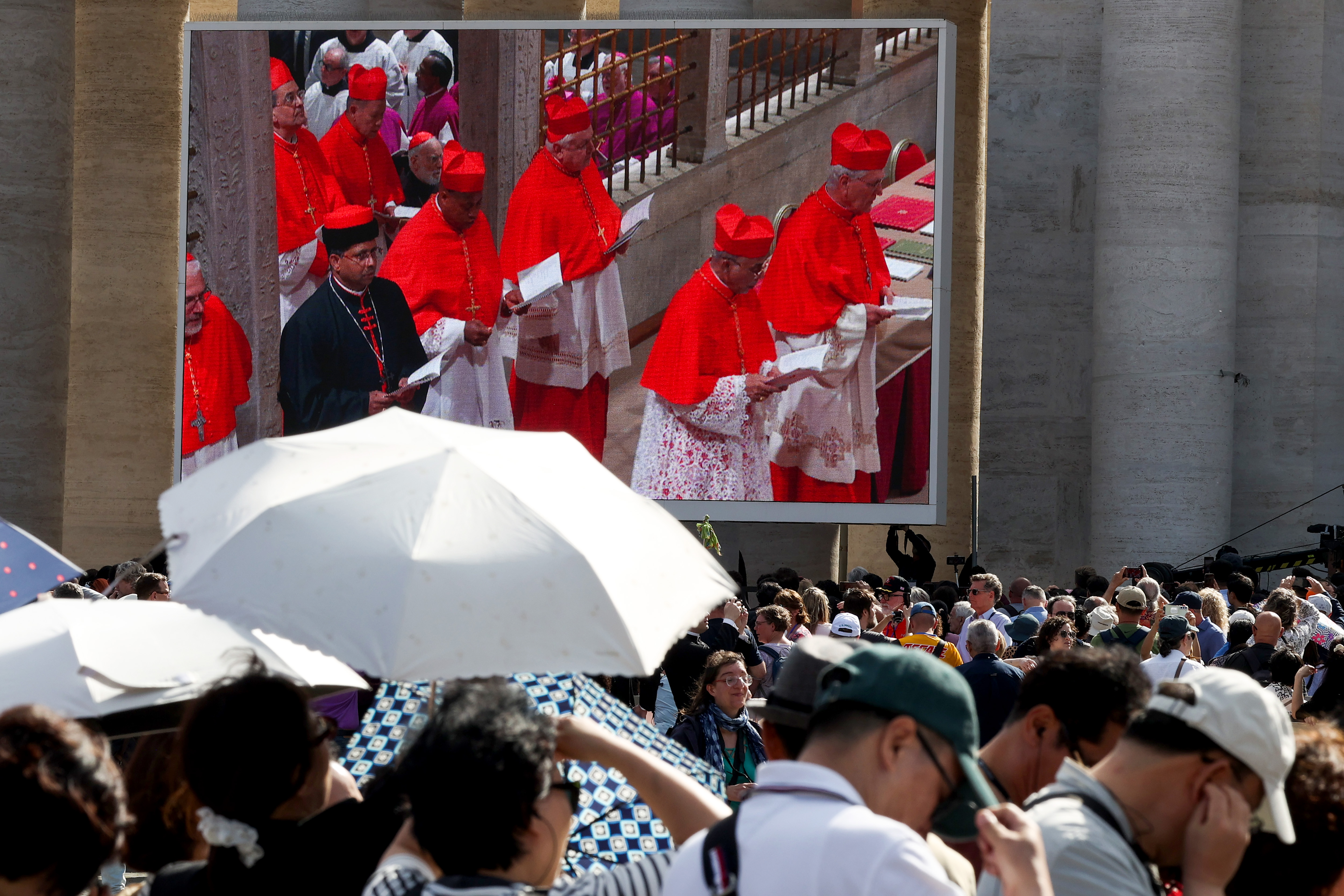 Les cardinaux entrent dans la chapelle Sixtine pour le conclave, montré sur les écrans de la place Saint-Pierre dans la Cité du Vatican le 7 mai 2025 | Source : Getty Images