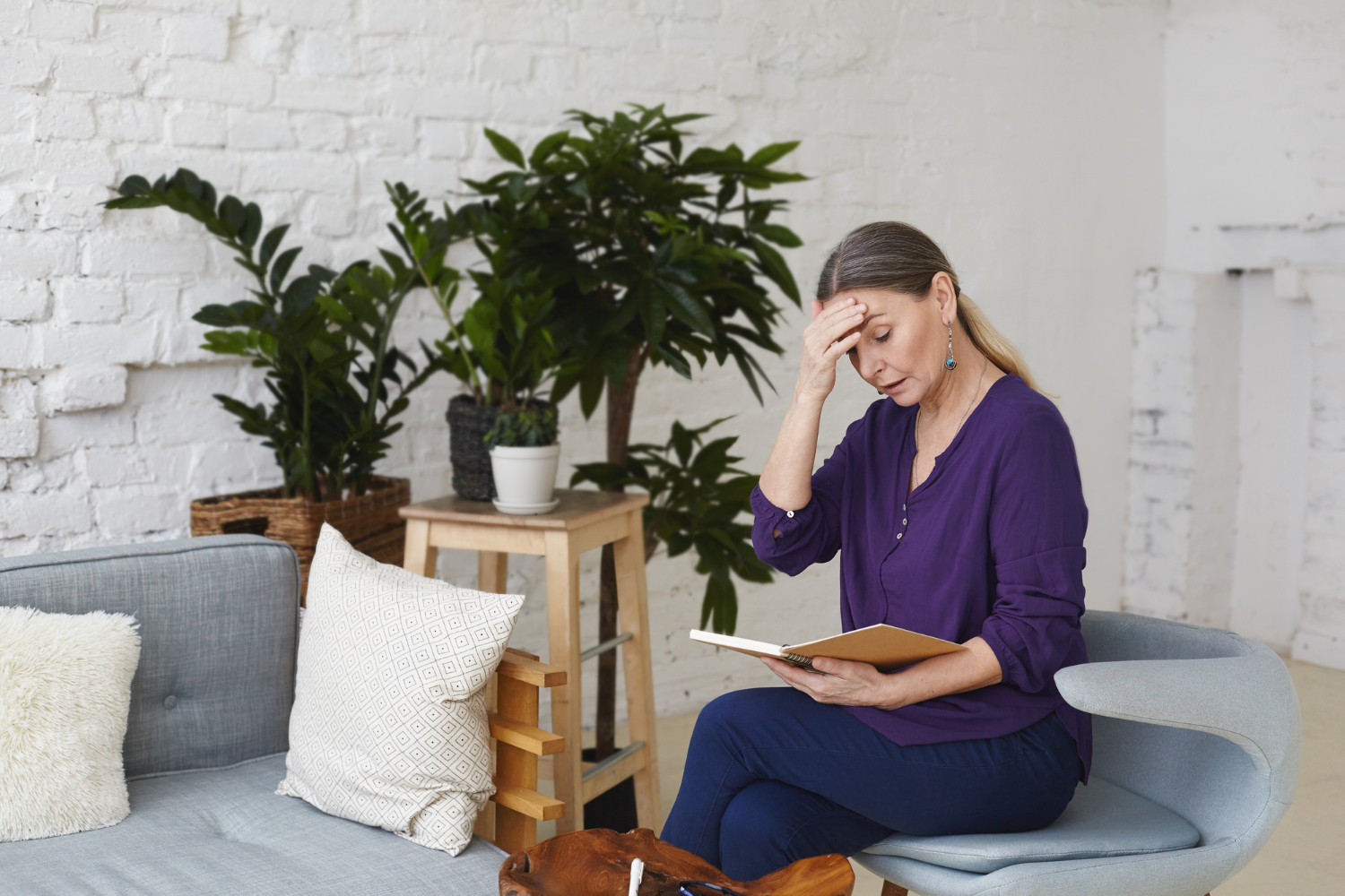 Une femme âgée découragée tenant un livre | Source : Freepik