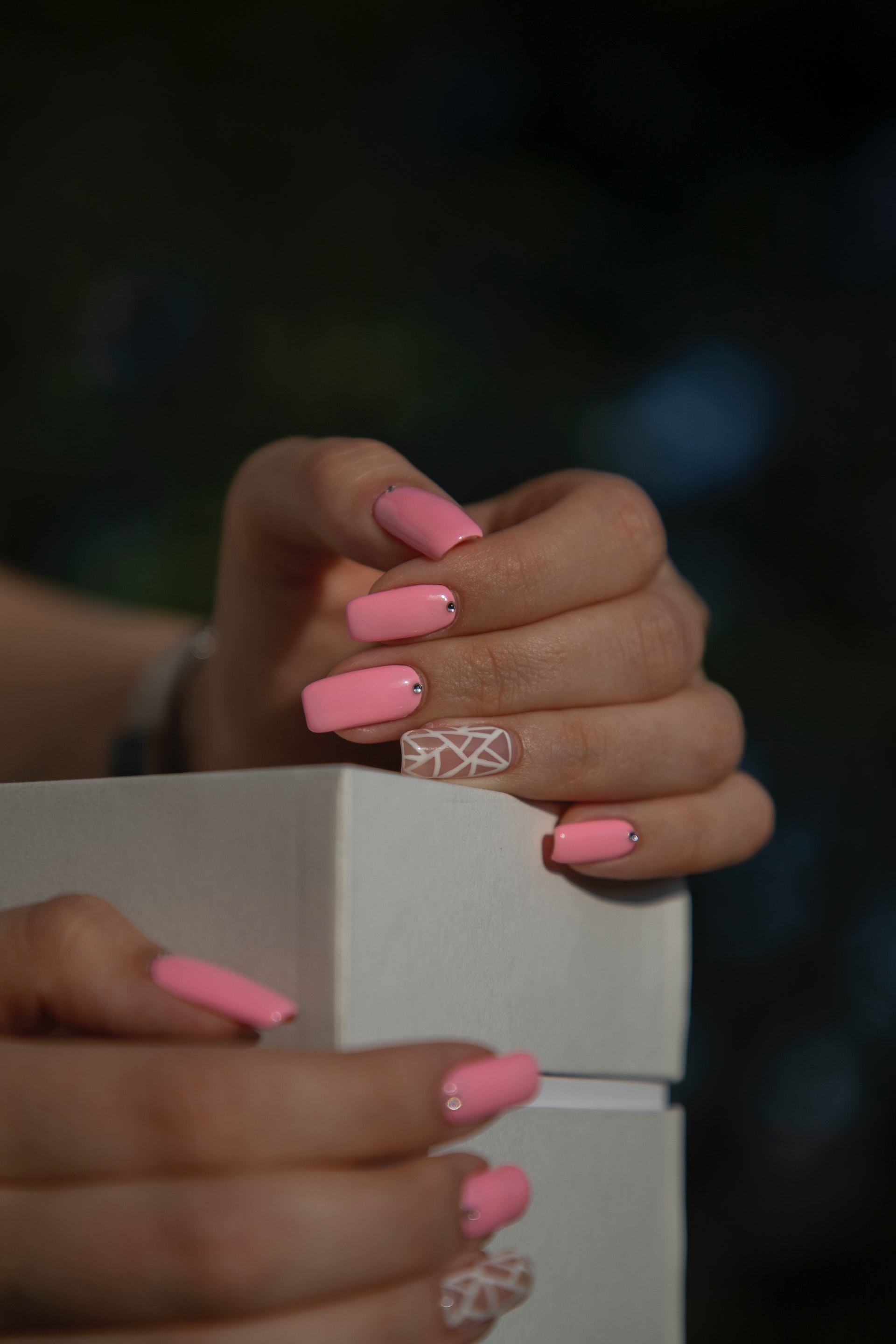 Mains féminines ornées de vernis à ongles rose | Source : Pexels